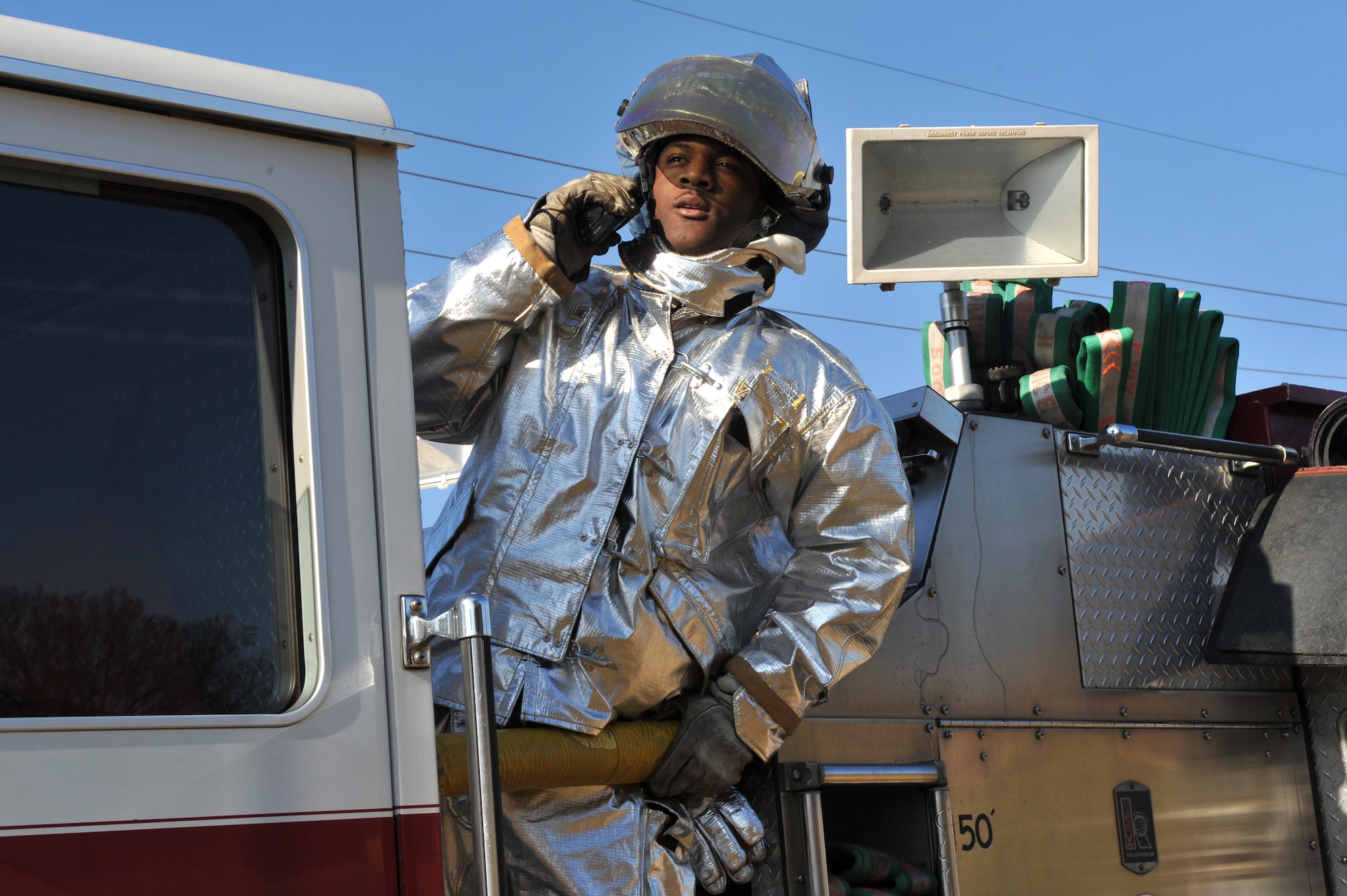 Senior Airman Levi Bonds, 19th Civil Engineer Squadron firefighter, coordinates with other members of the response team before putting out a controlled fire with the truck deck hose. Base members reacted to several simulated events during the March 19 MARE to hone their skills for real world situations. (U.S. Air Force Photo by Senior Airman Chris Willis)
