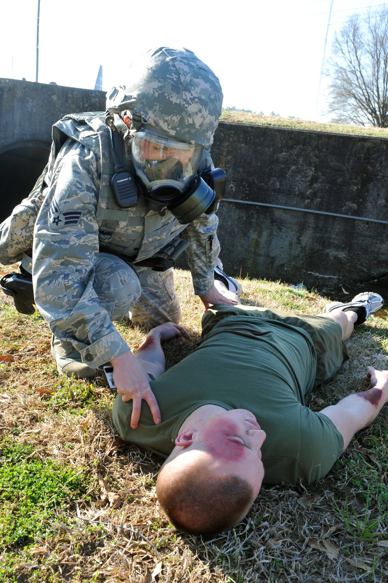Senior Airman Julianne Jones, 19th Security Forces Squadron desk sergeant, assist Marine Lance Cpl. Zack Dick, Marine Detachment Four barracks member, after he was "injured" March 19 during a simulated bomb attack. Several members of Little Rock Air Force Base participated in Major Accident Response Exercise in preparation for the 19th Airlift Wing Unit Compliance Inspection in April. (U.S. Air Force Photo by Senior Airman Chris Willis)