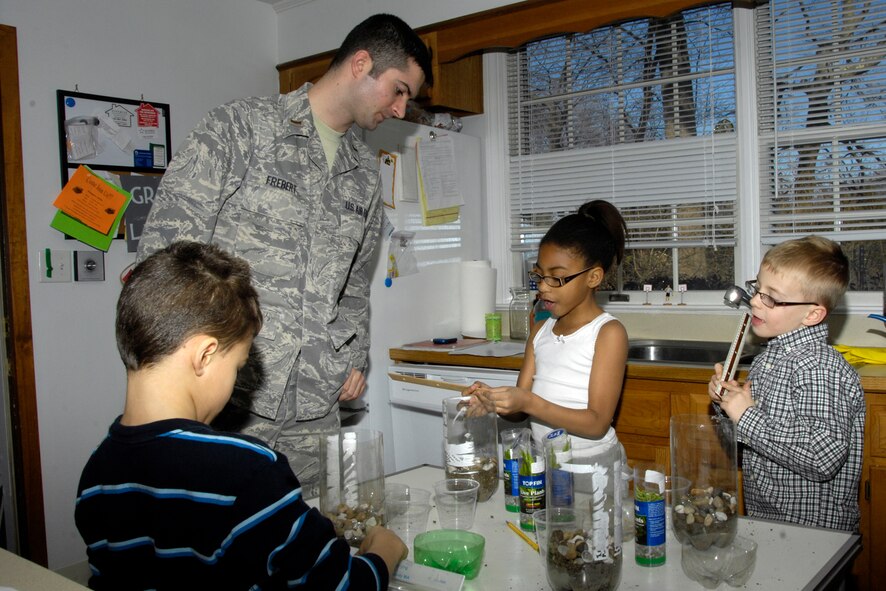 HANSCOM AIR FORCE BASE, Mass. – 2nd Lt. Matthew Frebert, 66th Air Base Wing commander’s action group, listens as Jameya Jenkins explains the process of creating a terrarium for an upcoming science fair. The tentative date for the science fair is April 13 at the Hanscom Primary School. From left to right are John Morkan, Lieutenant Frebert, Jameya Jenkins and Brian Thompson. In addition to creating the terrariums, the project offers the opportunity for military personnel to get engaged with base family members in the hopes of having fun and learning something new.  (U.S. Air Force photo by Linda LaBonte Britt)