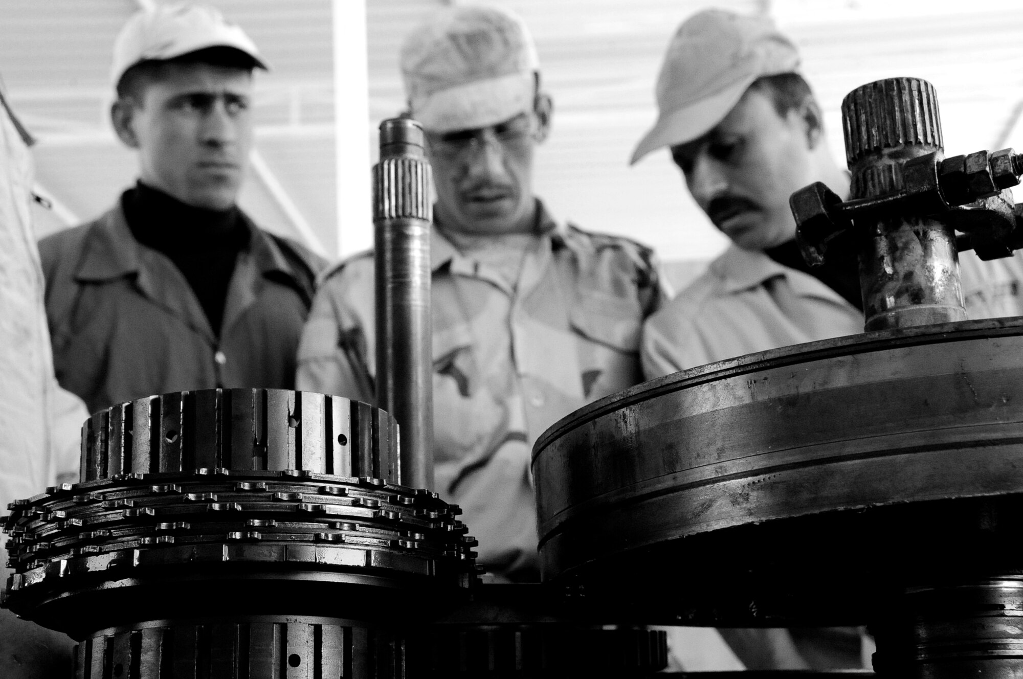 Three Iraqi Army vehicle maintenance technicians observe components of an Allison transmission during a transmission training course hosted by the Logistics Military Advisory Team at Camp Ur, Iraq March 22, 2010.  (U.S. Air Force photo by Staff Sgt. Miguel Lara III/released)