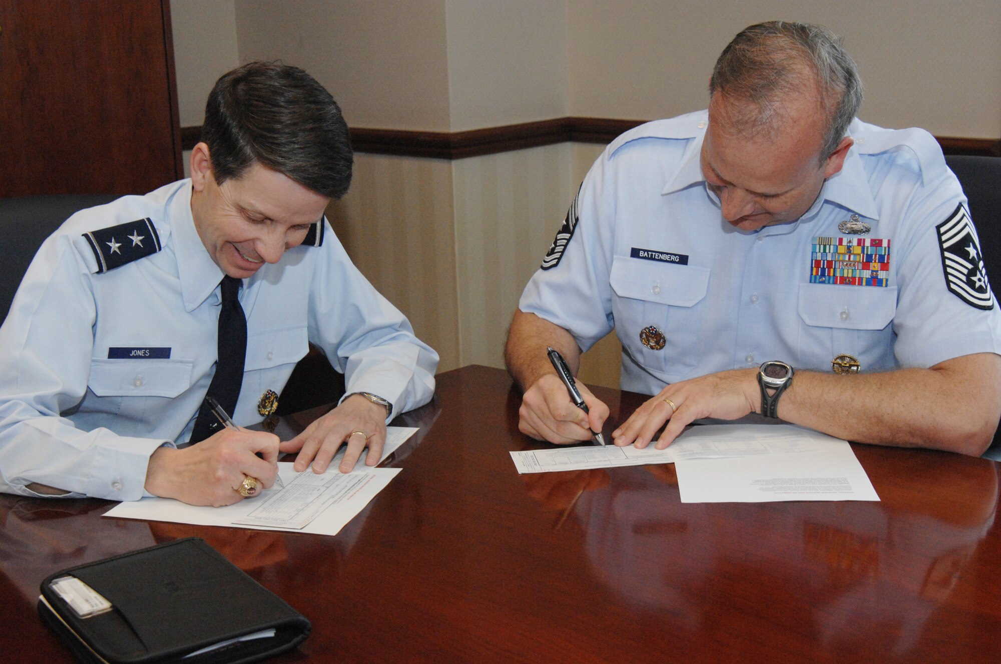 Air Force District of Washington Commander Maj. Gen. Darrell Jones, left and Command Chief Master Sgt. Pat Battenberg, right, sign Air Force Assistance Fund pledge forms March 22, 2010. The AFAF drive runs from March 15 to April 22 and supports major charities benefiting Airmen and their Families. Service members may elect to donate via monthly payroll deductions, while civilians and contractors are encouraged to make donations in the form of cash, check or money order. Contact you local AFAF POC to donate. 