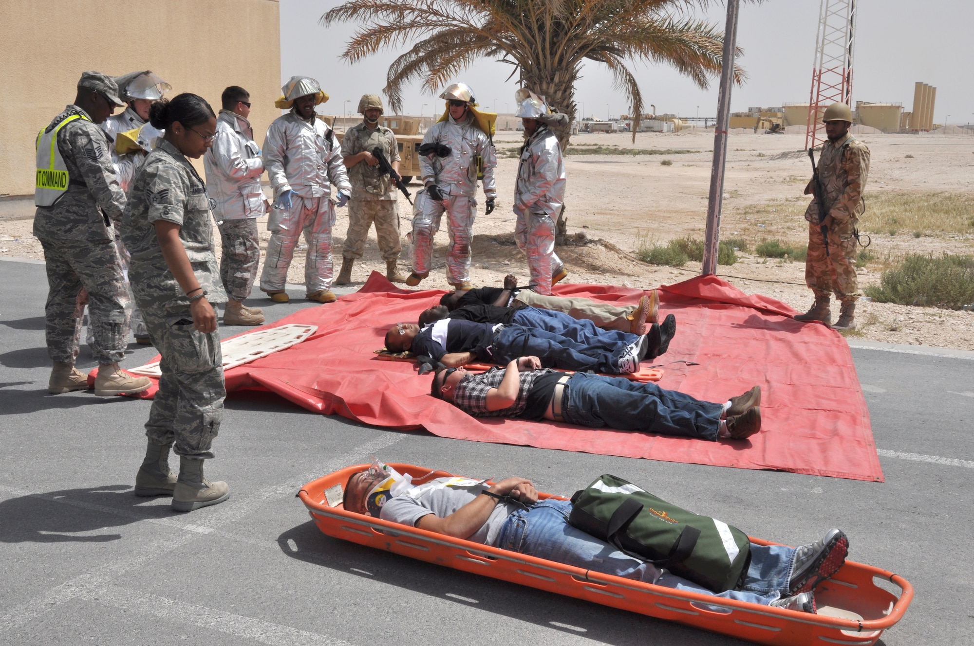 Members of the 379th Expeditionary Civil Engineer Squadron and 379th Expeditionary Medical Group monitor mock hostiles? health while host-nation members provide security during an exercise scenario at a non-disclosed Southwest Asia location March 23, 2010. (U.S. Air Force photo by Capt. Patrick Cordova)[RELEASED]