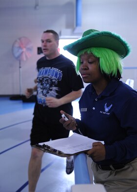 MINOT AIR FORCE BASE, N.D. -- Senior Airman Valerie King, 5th Force Support Squadron fitness specialist, shouts words of encouragement during the “St. Paddy’s Day relay race” at Minot AFB March 17. Each four-person team was comprised of two males and two females and required each team member to run 1.5 miles. The 5th Civil Engineer Squadron won the event with a combined run time of 40:34. (U.S. Air Force photo by Senior Airman Sharida Jackson)