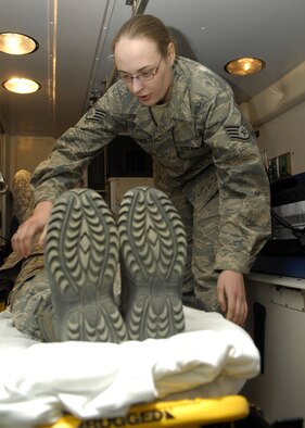 MINOT AIR FORCE BASE, N.D. – Staff Sgt. Amber Schumacher, 5th Medical Operations Squadron emergency medical technician, straps a patient onto a stretcher at Minot AFB March 17. Members of ambulance services work both twelve- and twenty-four hour shifts and stay prepared to respond to all emergencies. (U.S. Air Force photo by Airman 1st Class Ashley N. Avecilla)
