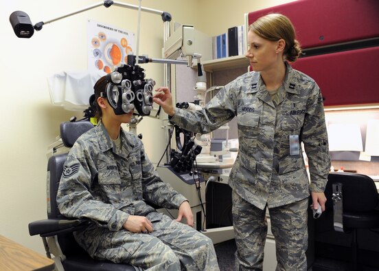 MINOT AIR FORCE BASE, N.D. -- Capt. Caitlyn Woods, 5th Medical Operations Squadron chief of optometry services, uses a phoropter on Staff Sgt. Catherine Martin, 5th Medical Group alternate personnel reliability program monitor, to check her vision and determine the correct prescription for her glasses March 11.  Regular eye exams can detect the beginning stages of degenerative eye disease and can restore or prolong vision for some incurable cases. (U.S. Air Force photo by Staff Sgt. Keith Ballard)