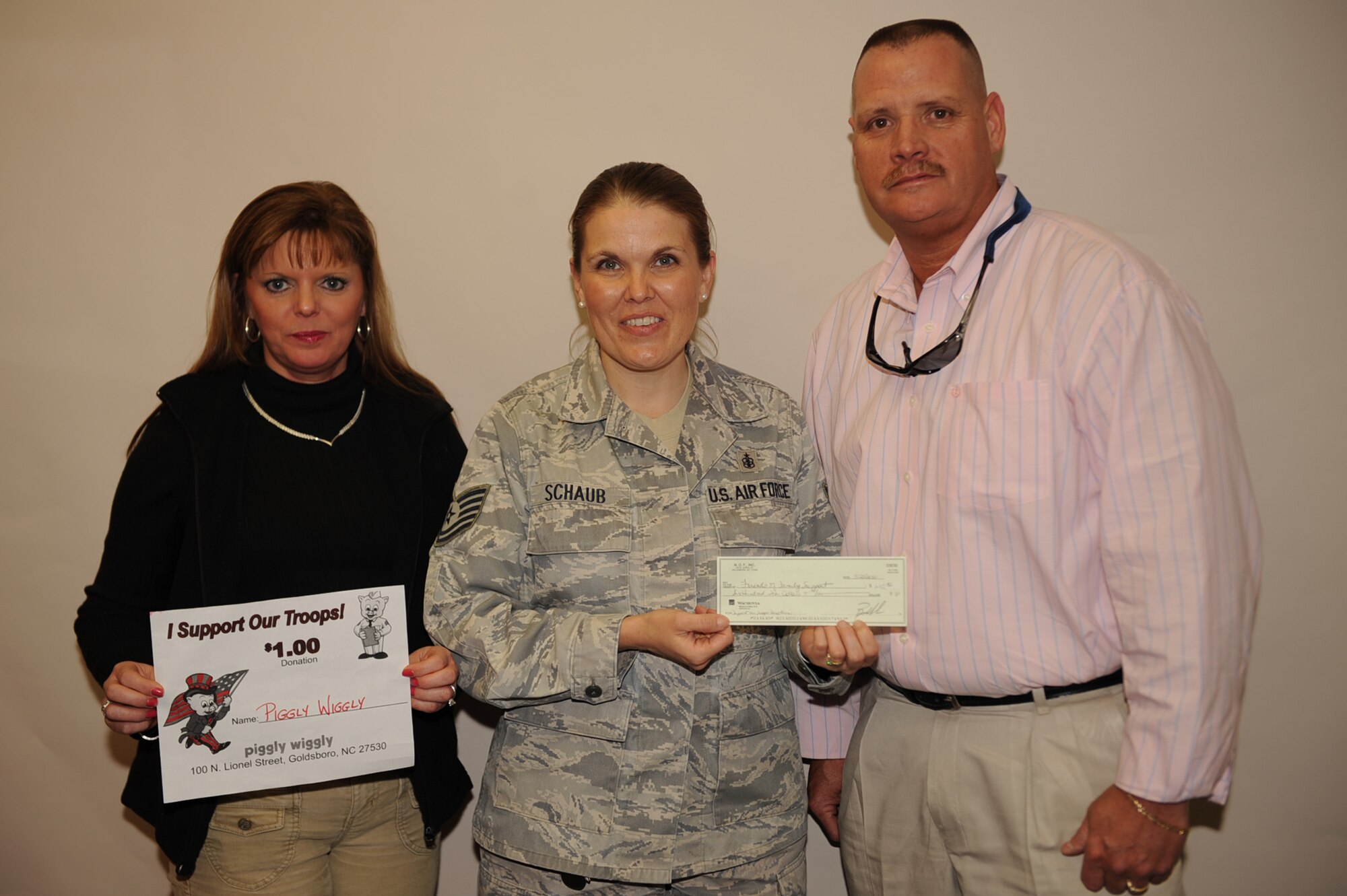 Piggly Wiggly employees Connie Ellis, scanning coordinator, and Billy Anderson, store manager, present a check to Tech. Sgt. Andrea Schaub, Airmen & Family Readiness Center noncommissioned officer in charge March 23, 2010. Schaub accepted the check on behalf of the A&FRC staff for events that bring the community together. For every dollar a customer donated, a donation card was displayed in the Piggly Wiggly store window. (U.S. Air Force photo/Senior Airman Ciara Wymbs) 