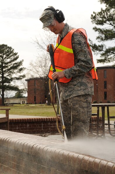 Airman 1st Class Jeremy Huuki, 335th Aircraft Maintenance Squadron aircraft armament journeyman, pressure washes bricks in the dormitory complex pavilion on Seymour Johnson Air Force Base, N.C., March 18, 2010. Huuki is on temporary duty for bay orderly, a program augmenting residents for a week to clean and perform minor maintenance around the dormitories. Huuki is from Houghton, Mich. (U.S. Air Force photo/Senior Airman Ciara Wymbs) 