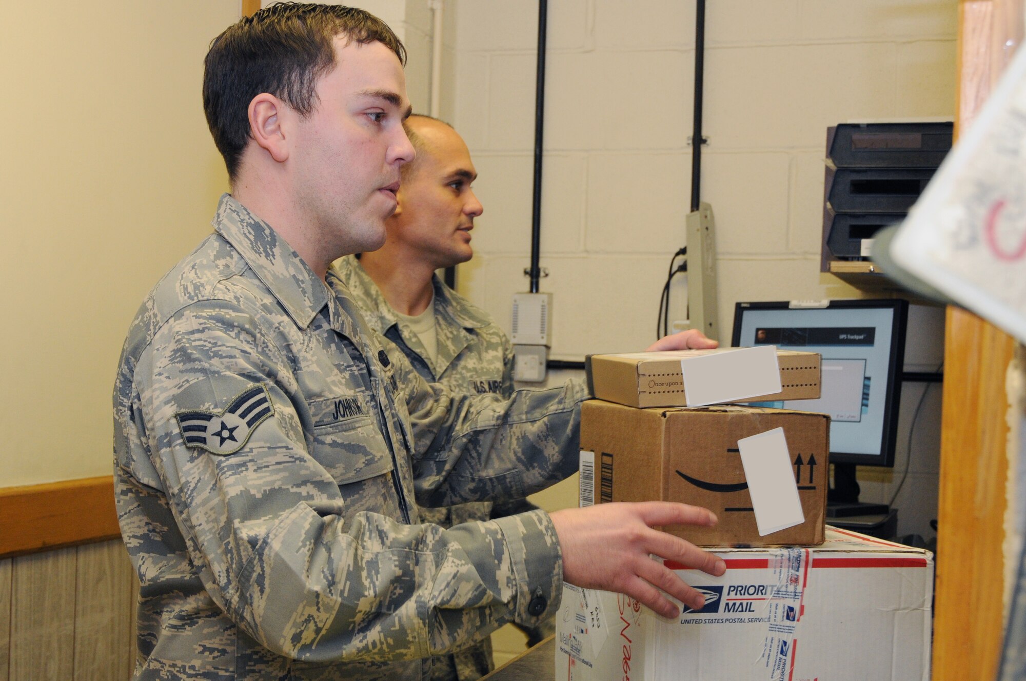 Senior Airman Marques Johnson and Staff Sgt. Hector Quinones, 48th Communications Squadron postal specialists, prepare customer packages for pick-up at the post office at RAF Lakenheath on March 12. The parcel pickup window is open from 10 a.m. to 4 p.m. Monday to Friday and 10 a.m.  to 1 p.m. on Saturdays. (U.S. Air Force photo by Airman 1st Class Lausanne Morgan)