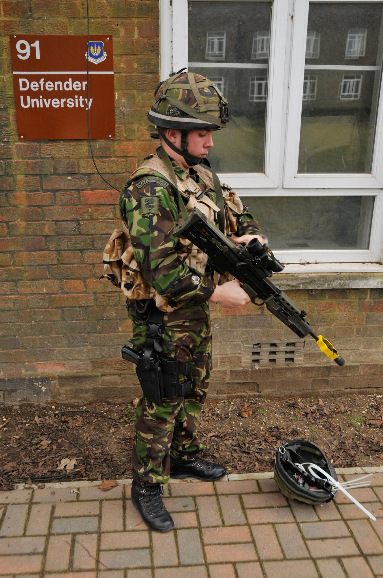 ROYAL AIR FORCE LAKENHEATH, England -- A Royal Air Force airman prepares for a tactical building clearing run through during a joint tactical training exercise at the 48th Security Forces Squadron Defense University at RAF Feltwell on March 3, 2010. Building clearing scenarios required team work and communication. (Photo by Airman 1st Class Eboni Knox)