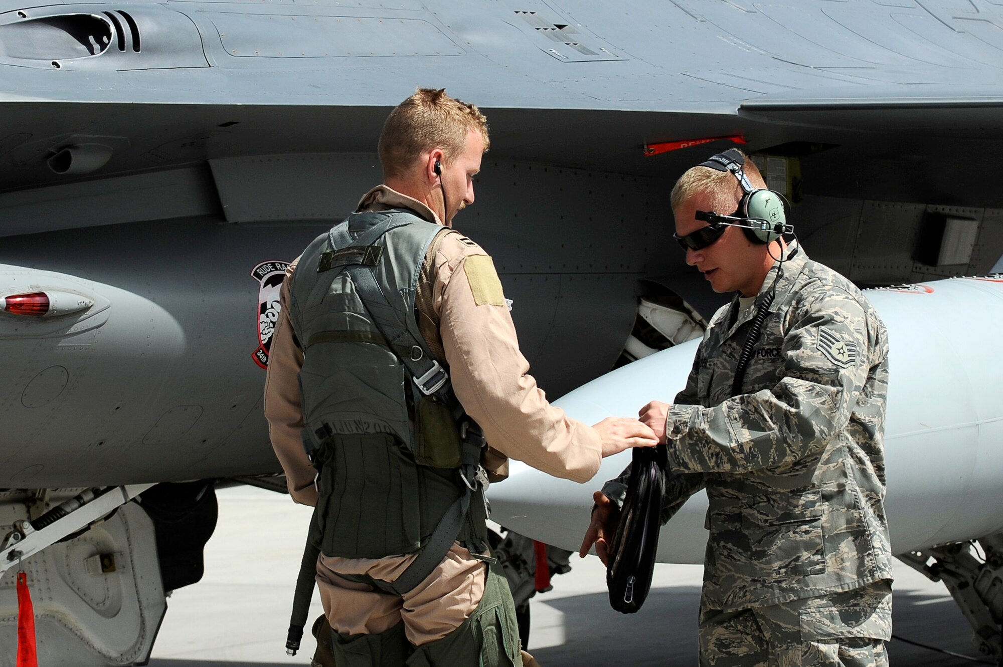U.S. Air Force Staff Sgt. Lucas Inboden, 34th Expeditionary Fighter Squadron, talks with the pilot of an F-16 after it completed 30 code 1 flights, at Bagram Airfield, Afghanistan, March 23, 2010. Sergeant Inboden is deployed from Hill Air Force Base, Utah, and is from Dallas, Texas. (U.S. Air Force photo by/ Tech. Sgt. Jeromy K. Cross/released)