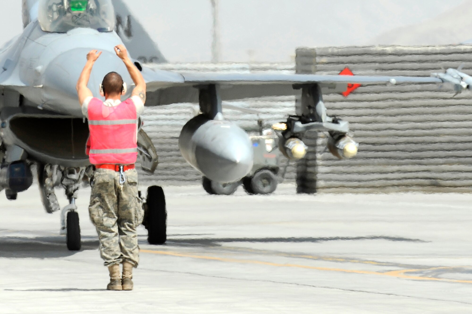 A U.S. Air Force Airman from the 34th Expeditionary Fighter Squadron recovers an F-16 at Bagram Airfield, Afghanistan, after the aircraft completed 30 code 1 flights, March 23, 2010. (U.S. Air Force photo by/ Tech. Sgt. Jeromy K. Cross/released)