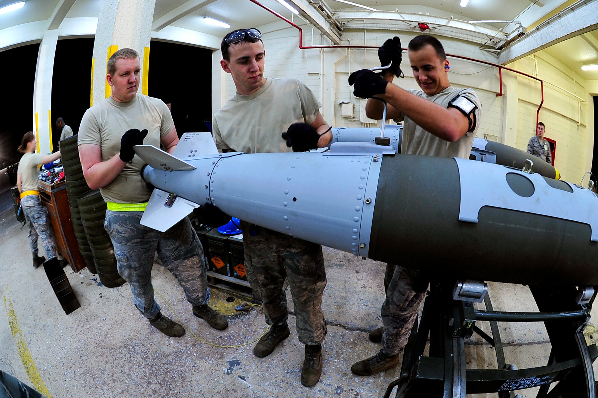 Airmen from the 18th Munitions Squadron attach the tail-ends of Mark 83 bomb bodies during Beverly High 10-02 at Kadena Air Base, Japan, March 24. The 18th Wing is participating in a Local Operational Readiness Exercise March 22-26 to test the readiness of Kadena Airmen.  (U.S. Air Force photo/Senior Airman Amanda Grabiec)        