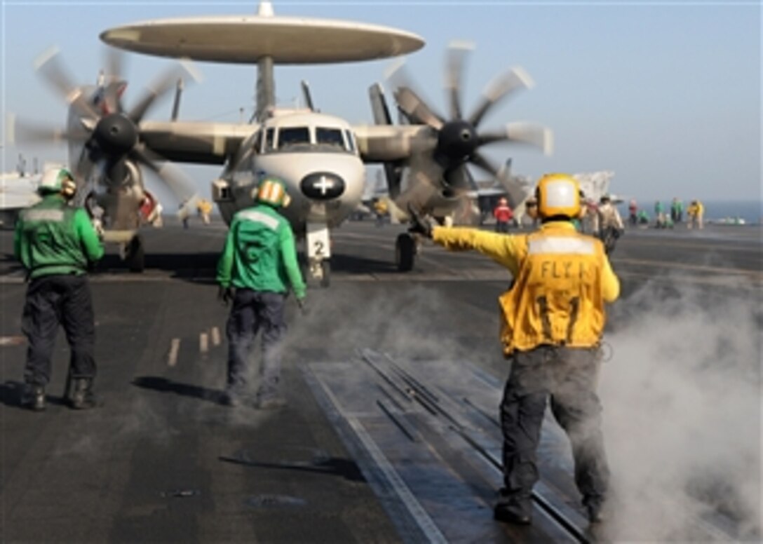 A U.S. Navy sailor directs an E-2C Hawkeye aircraft assigned to Airborne Early Warning Squadron 121 up to the catapult on the flight deck of the aircraft carrier USS Dwight D. Eisenhower (CVN 69) in the North Arabian Sea on March 22, 2010.  The Eisenhower is on a six-month deployment as a part of the ongoing rotation of forward-deployed forces.  