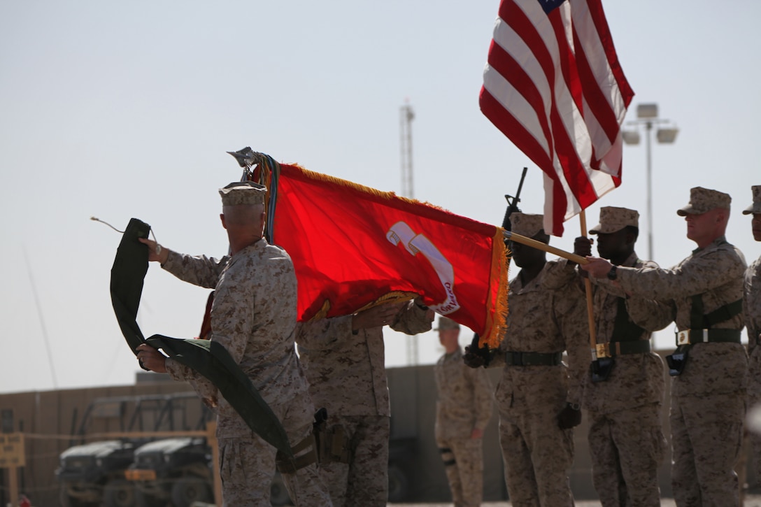 Brig. Gen. Charles L. Hudson and Sgt. Maj. Antonio N. Vizcarrondo Jr. uncase the 1st Marine Logistics Group colors during the Transfer of Authority ceremony at Camp Leatherneck, Afghanistan, March 24. The uncasing of the colors signifies the start of 1st MLG's mission in Afghanistan as the Logistics Combat Element.