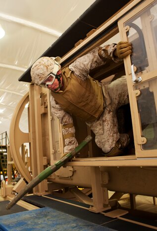 Sgt. Lucas Hartman, combat operations center watch chief, Headquarters Company, Combat Logistics Battalion 3, egresses out of the new Mine Resistant Ambush Protected Egress Trainer, or MET, at Boondocker Training Area on base March 24. Hartman participated in the training along with other CLB-3 Marines and sailors to fulfill a pre-deployment training requirement prior to a fall 2010 deployment in support of Operation Enduring Freedom.