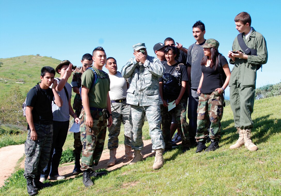 Technical Sgt. Raul Quintero, an aircrew flight equipment craftsman with the 452nd Operational Support Squadron, demonstrates how to use a compass to locate a specific point in the hilly terrain of Sycamore Park in Riverside during an Air Force  Junior ROTC land navigation lesson in land navigation. The 11 students in Sergeant Quintero’s group are in Air Force Junior ROTC at Moreno Valley High School and the class is comprised of sophomores, juniors and seniors. The students did so well, that they were tasked with mapping and finding additional locations. Sergeant Quintero is an avid volunteer in the local community who has worked with Boy Scouts and Cub Scouts, and given presentations at local schools and to veterans organizations. (U.S. Air Force photo by Staff Sgt. Megan Crusher)