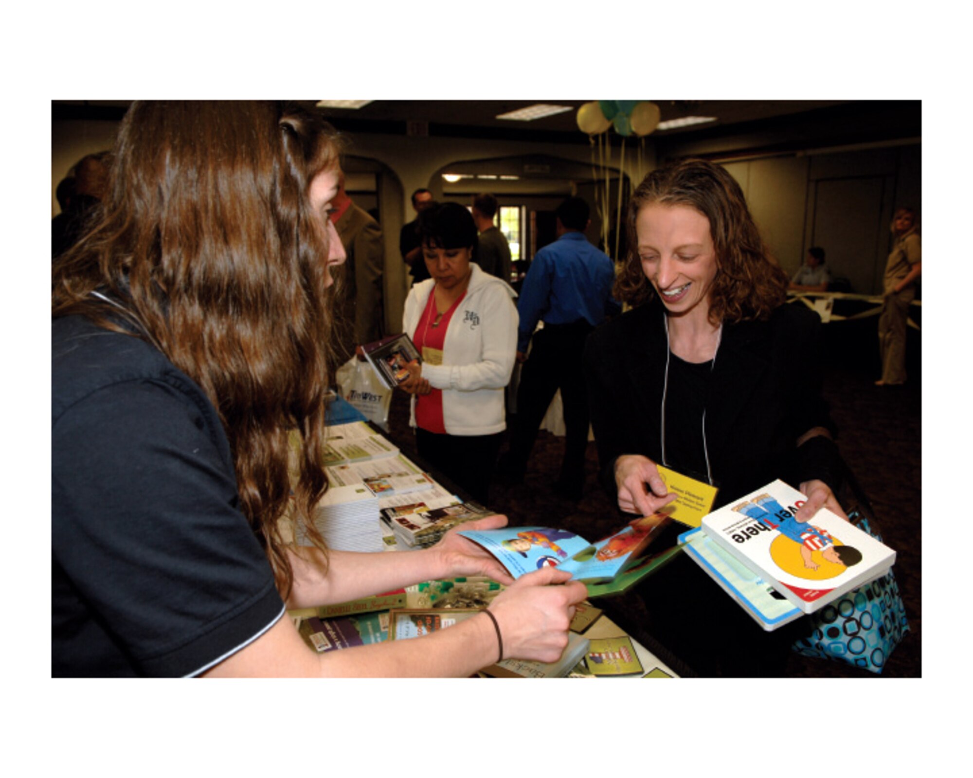 Jessica Whelchel, Military OneSource consultant, holds a copy of “Over There,” a children’s board book about a father’s deployment, as she talks with Kristen Pleasant, wife of Senior Airman Kevin Pleasant, 452nd Maintenance Squadron, about Military OneSource resources for kids during the Yellow Ribbon event at March ARB, Mar. 11. The Yellow Ribbon Reintegration Program is a Department of Defense-sponsored event designated to link deploying Reserve service members and their families with agencies who offer services and support before, during and after the deployment. (U.S. Air Force photo by Senior Airman Matthew Smith)
