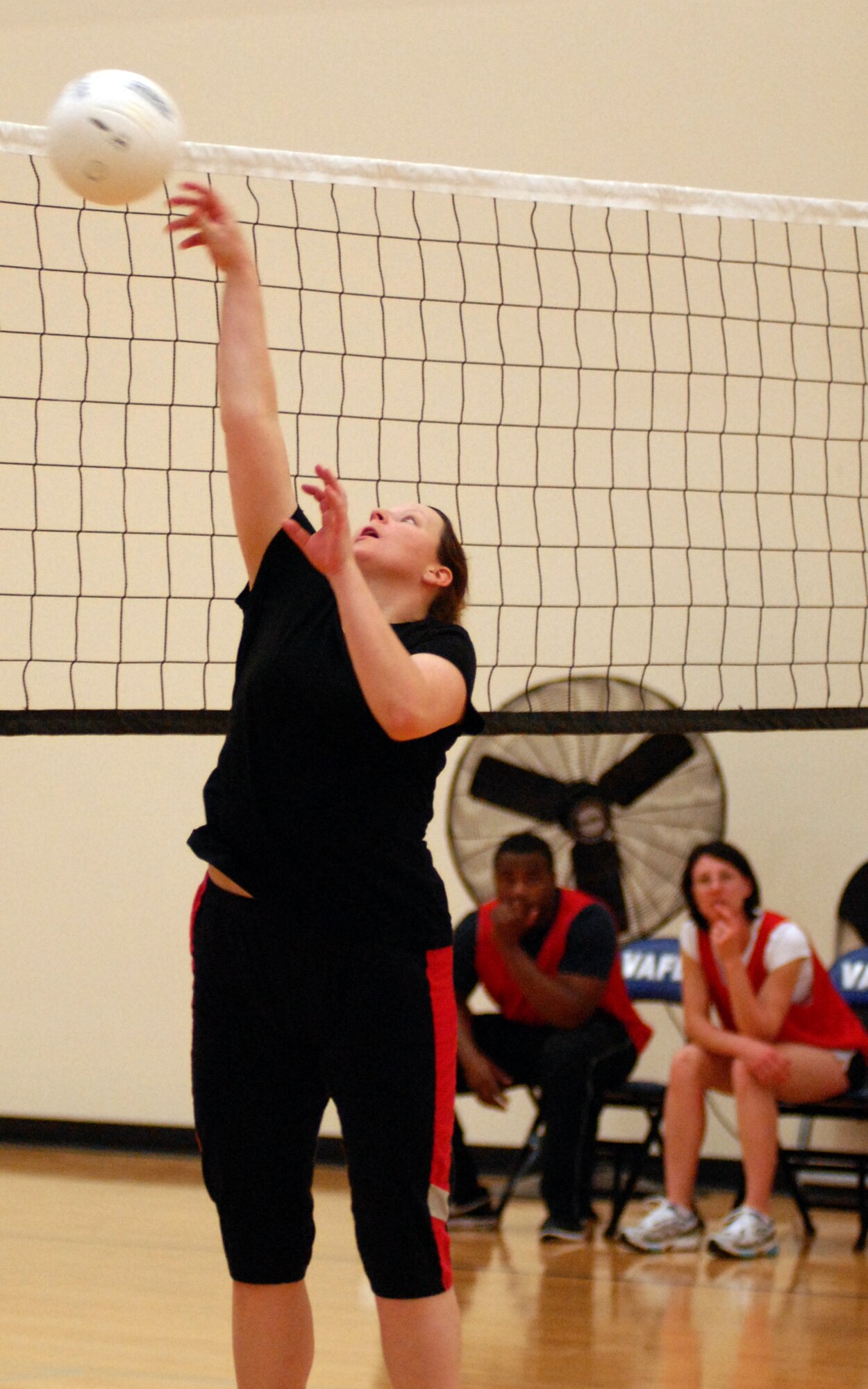 VANDENBERG AIR FORCE BASE, Calif. - - Protecting her team's side of the court from an opponent attack near the net, Ashley Williamson, a member of the 30th Space Wing Staff Agencies team, pops the ball up and over the net during an intramural volleyball game here Wednesday, March 24, 2010. The 30th SW Staff Agencies won the game 2-1 against the 30th Space Communications Squadron team. (U.S. Air Force photo/Airman 1st Class Angelina Drake)