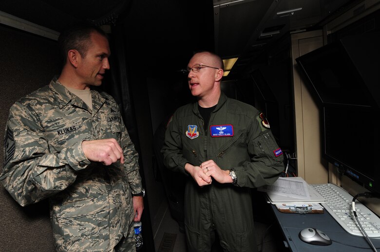 CREECH AIR FORCE BASE, Nev. -- Master Sgt. Kelly Clark, 11th Reconnaissance Squadron, airborne battle management systems manager, gives a tour of a Ground Control Station (GCS) to Chief Master Sgt. Martin Klukas, command chief of Air Combat Command, here March 5.  Chief Klukas toured Creech facilities and spoke with Airmen to gain a perspective on their mission and quality of life. (U.S. Air Force Photo by Staff Sgt. William P. Coleman)
