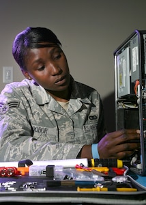 Senior Airman Maureen Edobor, 802nd Communications Squadron, removes the power supply from a computer. The 802nd CS maintains all communications, information management. (U.S. Air Force photo/Robbin Cresswell)