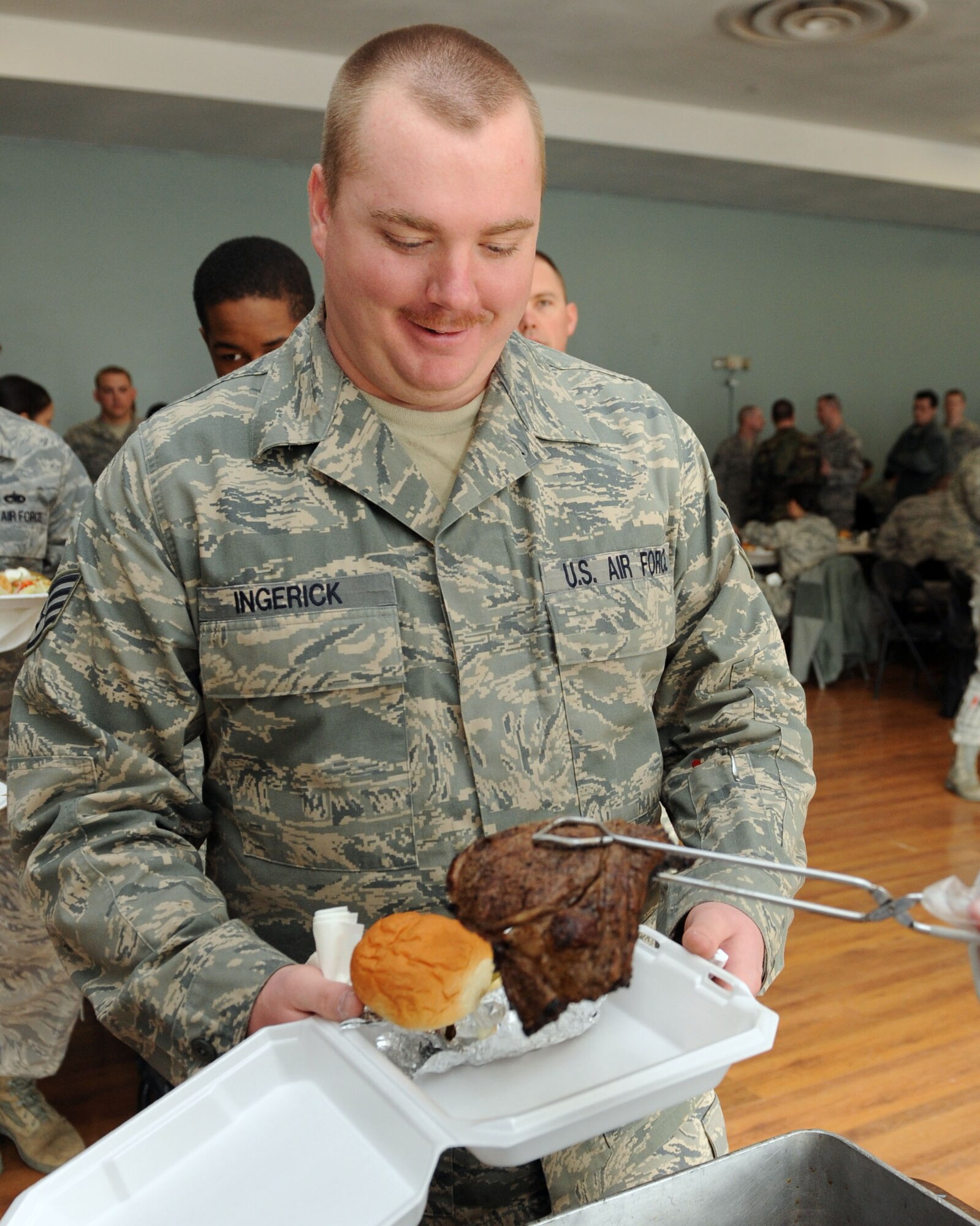 MOUNTAIN HOME AIR FORCE BASE, Idaho -- Staff Sgt. Kevin Ingerik, 366th Logistics Readiness Squadron NCOIC of licensing, gets a steak at the community center during the Chief’s Steak Burn March 17. Money raised from the steak burn helps offset costs of quarterly and annual awards. (U.S. Air Force photo by Airman 1st Class Debbie Lockhart)