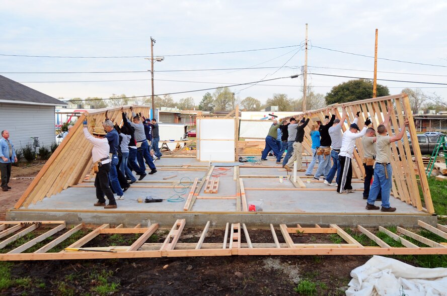 SHREVEPORT, La. – Members of the local community and Airmen from Barksdale Air Force Base raise the exterior walls of a Habitat for Humanity home March 20. More than 20 Barksdale Airmen from the 2d Civil Engineer Squadron volunteered to help with the construction. (U.S. Air Force photo by Senior Airman Joanna M. Kresge)