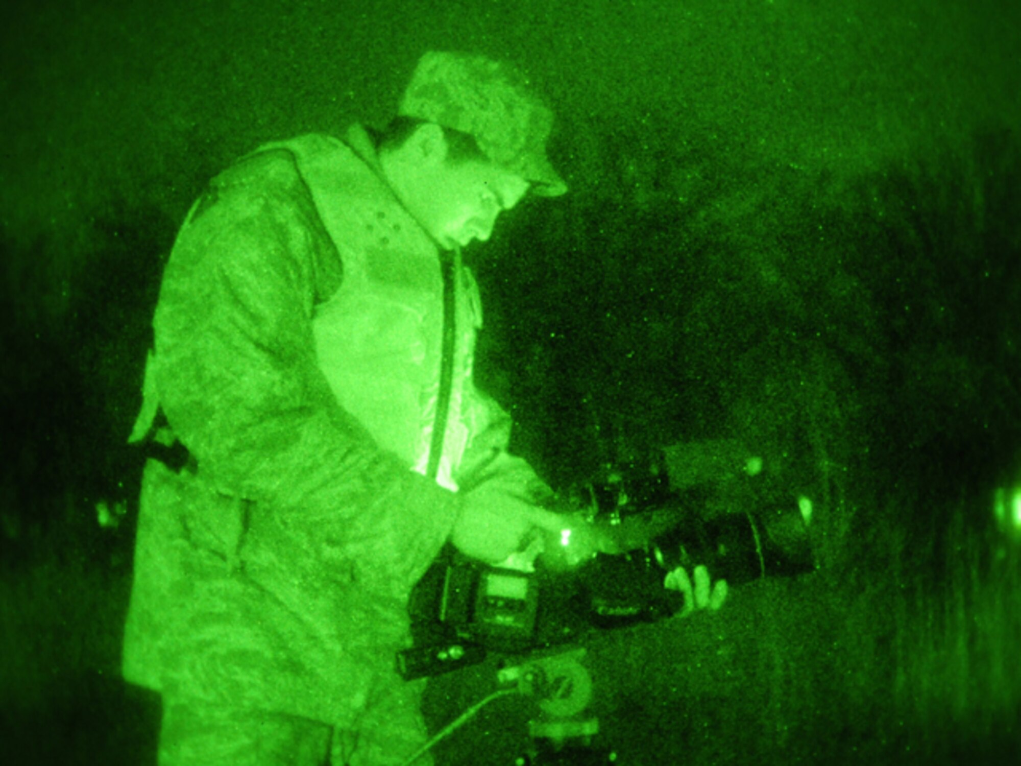 Senior Airman Nathanael Baardson, of the 119th Wing, uses a night-vision lens to videotape a pair of North Dakota National Guard quick response force (QRF) team members March 24 as they monitor floodwater along levees in Harwood, N.D. Baardson is a member of the N.D. National Guard public affairs team documenting the activities of the military flood mission for historical, internal Department of Defense briefings and civilian media relations purposes. (DoD photo by Senior Master Sgt. David H. Lipp) (Released)
