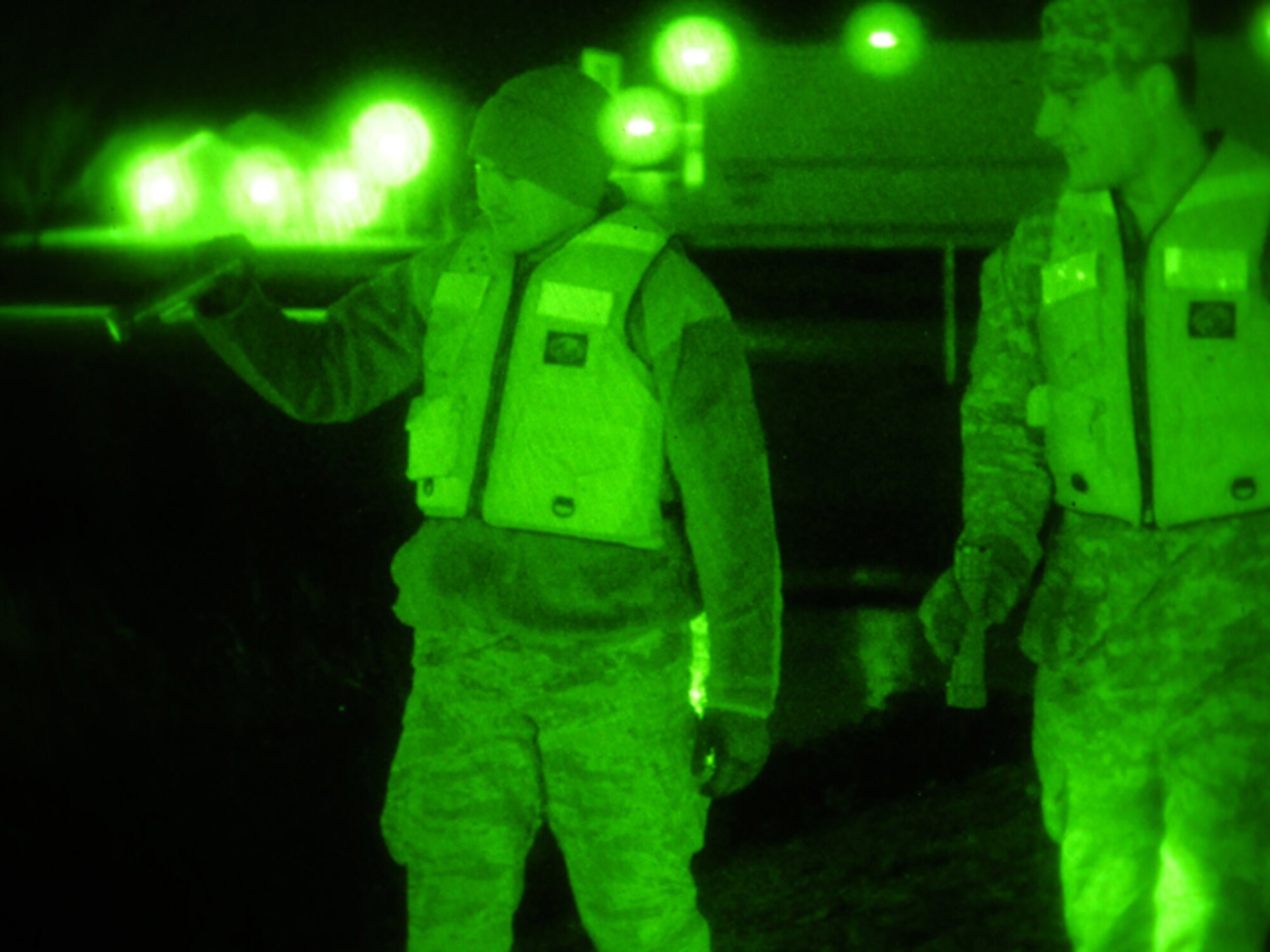 Senior Airman Anthony Rezac, of the 119th Civil Engineer Squadron, (left) and Spc. Nick Strom, of the 815th Engineer Company (Wishek, N.D.), walk along an earthen levee using flashlights during the evening hours of March 24 in Harwood, N.D. The pair of North Dakota National Guard members are part of a quick reaction force (QRF) team staging out of the Harwood Community Center who take a turn monitoring the floodwater as residents sleep. The residents of Harwood are able to monitor the levees themselves during the daylight hours. The nighttime levee walking is one the remaining tasks for the QRF teams as much of the floodwater in the area begins to recede. (DoD photo by Senior Master Sgt. David H. Lipp) (Released)

