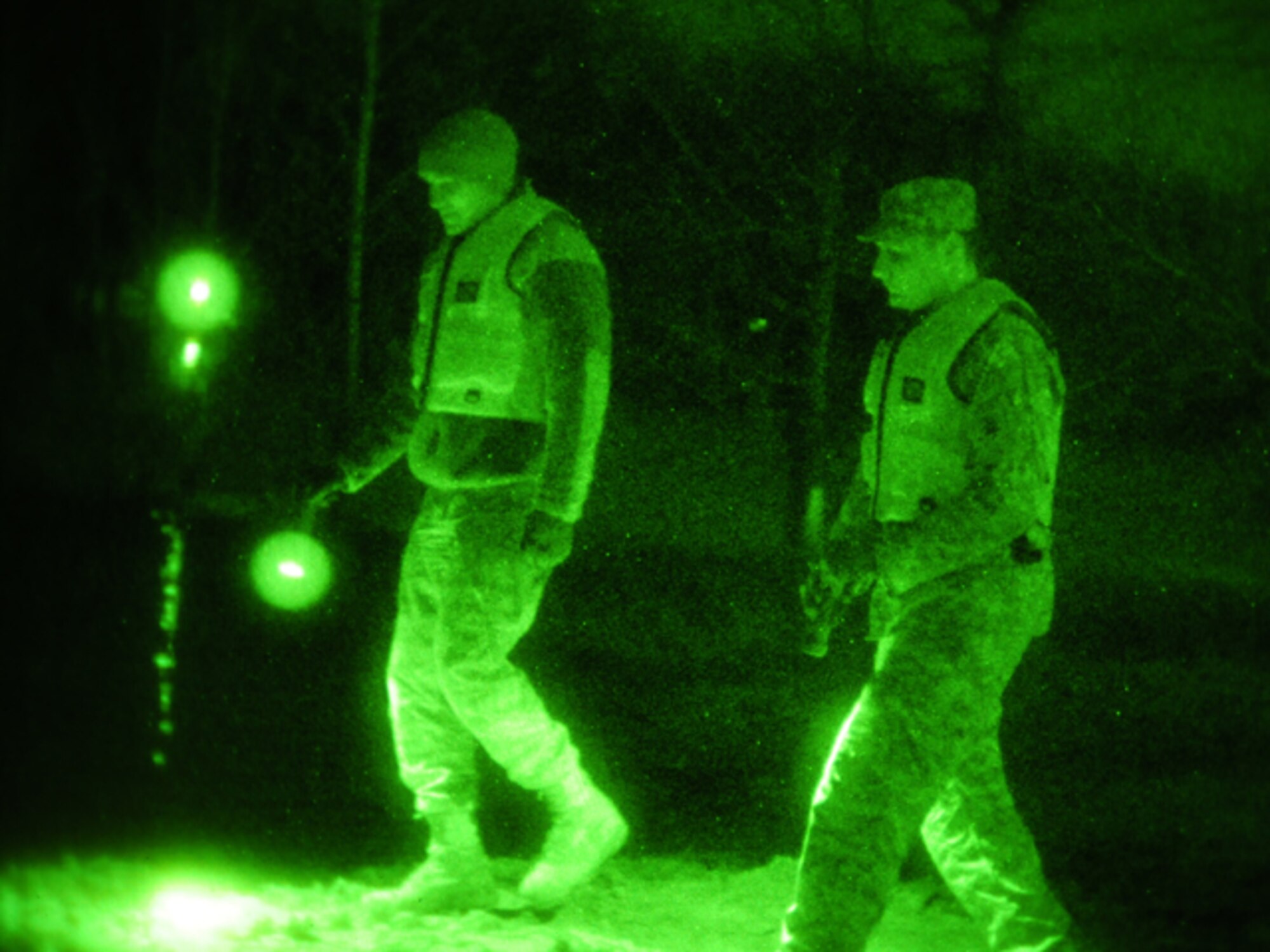 Senior Airman Anthony Rezac, of the 119th Civil Engineer Squadron, (left) and Spc. Nick Strom, of the 815th Engineer Company (Wishek, N.D.), walk along an earthen levee using flashlights during the evening hours of March 24 in Harwood, N.D. The pair of North Dakota National Guard members are part of a quick reaction force (QRF) team staging out of the Harwood Community Center who take a turn monitoring the floodwater as residents sleep. The residents of Harwood are able to monitor the levees themselves during the daylight hours. The nighttime levee walking is one the remaining tasks for the QRF teams as much of the floodwater in the area begins to recede. (DoD photo by Senior Master Sgt. David H. Lipp) (Released)

