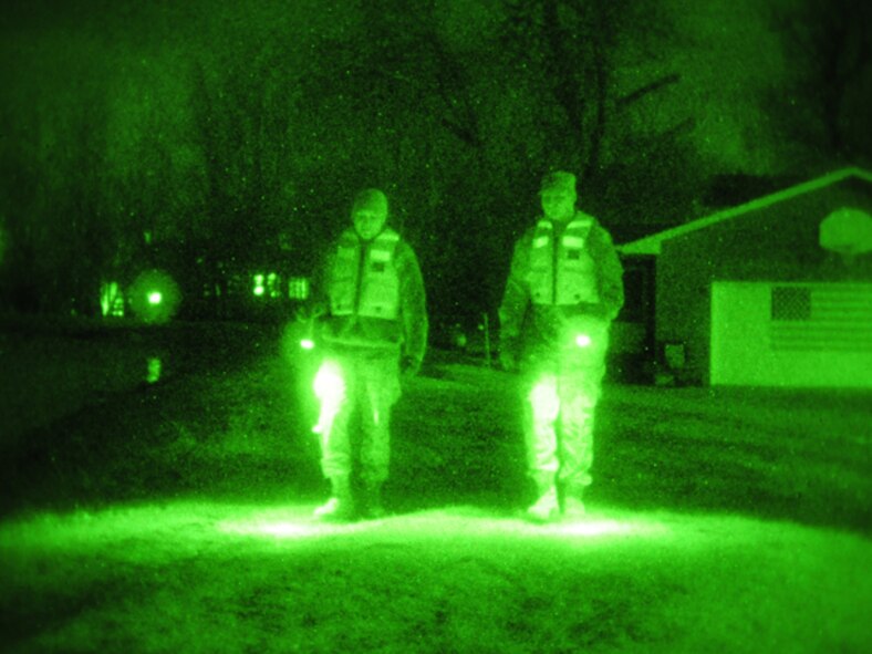 Senior Airman Anthony Rezac, of the 119th Civil Engineer Squadron, (left) and Spc. Nick Strom, of the 815th Engineer Company (Wishek, N.D.), walk along an earthen levee using flashlights during the evening hours of March 24 in Harwood, N.D. The pair of North Dakota National Guard members are part of a quick reaction force (QRF) team staging out of the Harwood Community Center who take a turn monitoring the floodwater as residents sleep. The residents of Harwood are able to monitor the levees themselves during the daylight hours. The nighttime levee walking is one the remaining tasks for the QRF teams as much of the floodwater in the area begins to recede. (DoD photo by Senior Master Sgt. David H. Lipp) (Released)

