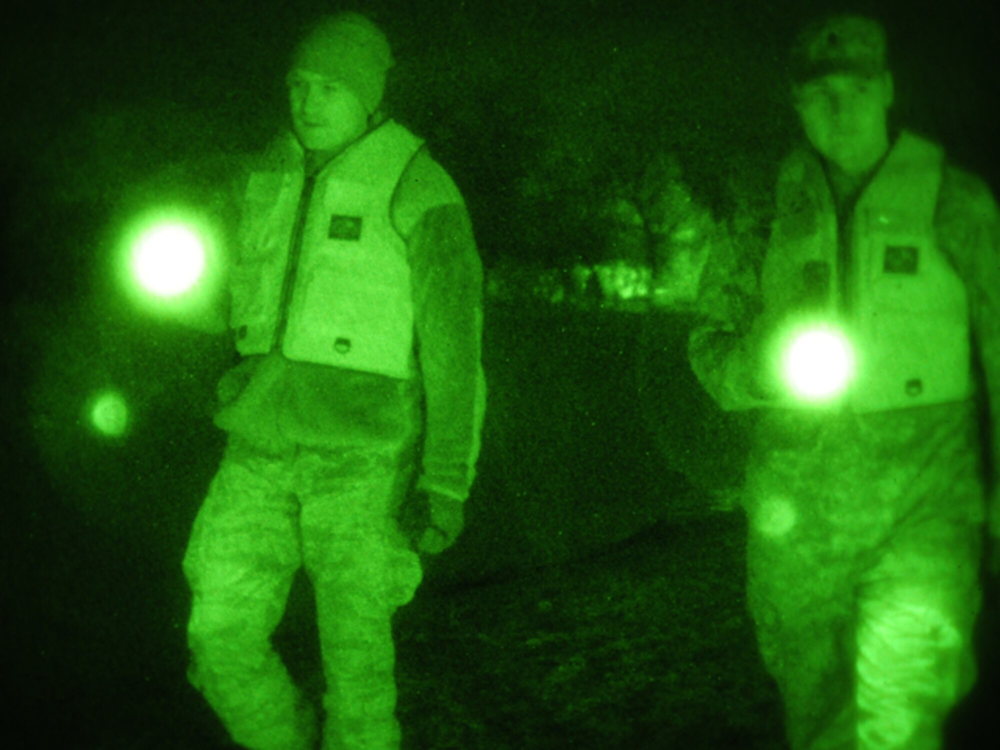 Senior Airman Anthony Rezac, of the 119th Civil Engineer Squadron, (left) and Spc. Nick Strom, of the 815th Engineer Company (Wishek, N.D.), walk along an earthen levee using flashlights during the evening hours of March 24 in Harwood, N.D. The pair of North Dakota National Guard members are part of a quick reaction force (QRF) team staging out of the Harwood Community Center who take a turn monitoring the floodwater as residents sleep. The residents of Harwood are able to monitor the levees themselves during the daylight hours. The nighttime levee walking is one the remaining tasks for the QRF teams as much of the floodwater in the area begins to recede. (DoD photo by Senior Master Sgt. David H. Lipp) (Released)

