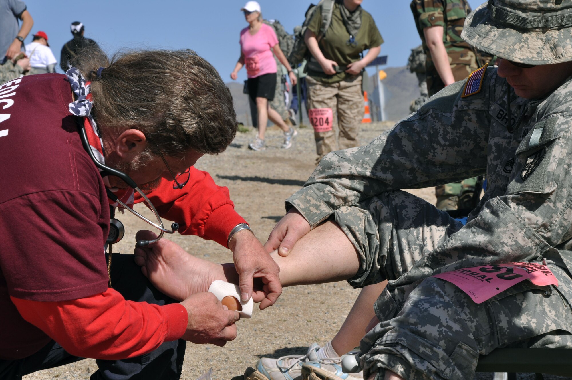 WHITE SANDS MISSILE RANGE, N.M. -- A participant of the 21st Annual Bataan Memorial Death March receives medical attention at one of five medical stations along the 26.2 mile trail, March 21, 2010. The Bataan Memorial Death March commemorates the Bataan Death March which occurred in the Philippines during World War II. On April 9, 1942, 75,000 Army, Army Air Corps, Navy, Marine and Filipino soldiers were surrendered to Japanese forces. Forced to march 60 miles in the sweltering heat through the Philippine jungles, thousands of soldiers died in transit to prisoner-of-war camps. A record of more than 5,700 military and civilian marchers attended the 21st Annual Bataan Memorial Death March. (U.S. Air Force photo by Airman 1st Class Joshua Turner) (Released)
