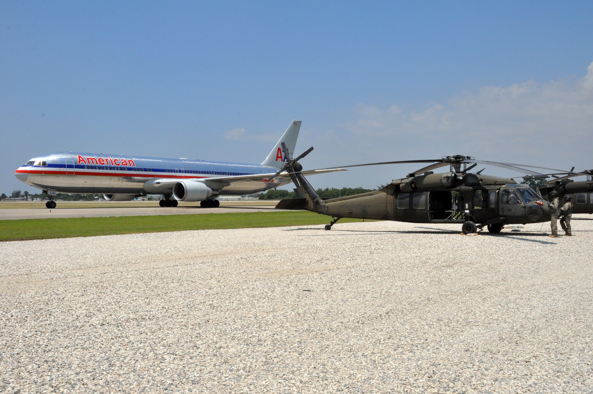 Aircrew members from the 1st Battalion, 228th Aviation Regiment, wait for an American Airline jet at Toussaint Louverture International Airport to pass before they can lift off for a mission in support of Joint Task Force-Haiti. Joint Task Force-Bravo deployed more than 45 members in support of JTF-Haiti, the U.S. military's task force assisting in disaster relief efforts in Haiti following the Jan. 12 earthquake as part of Operation Unified Response. (U.S. Air Force photo/Staff Sgt. Bryan Franks)