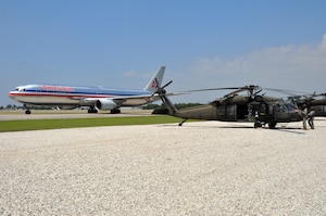 Aircrew members from the 1st Battalion, 228th Aviation Regiment, wait for an American Airline jet at Toussaint Louverture International Airport to pass before they can lift off for a mission in support of Joint Task Force-Haiti. Joint Task Force-Bravo deployed more than 45 members in support of JTF-Haiti, the U.S. military's task force assisting in disaster relief efforts in Haiti following the Jan. 12 earthquake as part of Operation Unified Response. (U.S. Air Force photo/Staff Sgt. Bryan Franks)