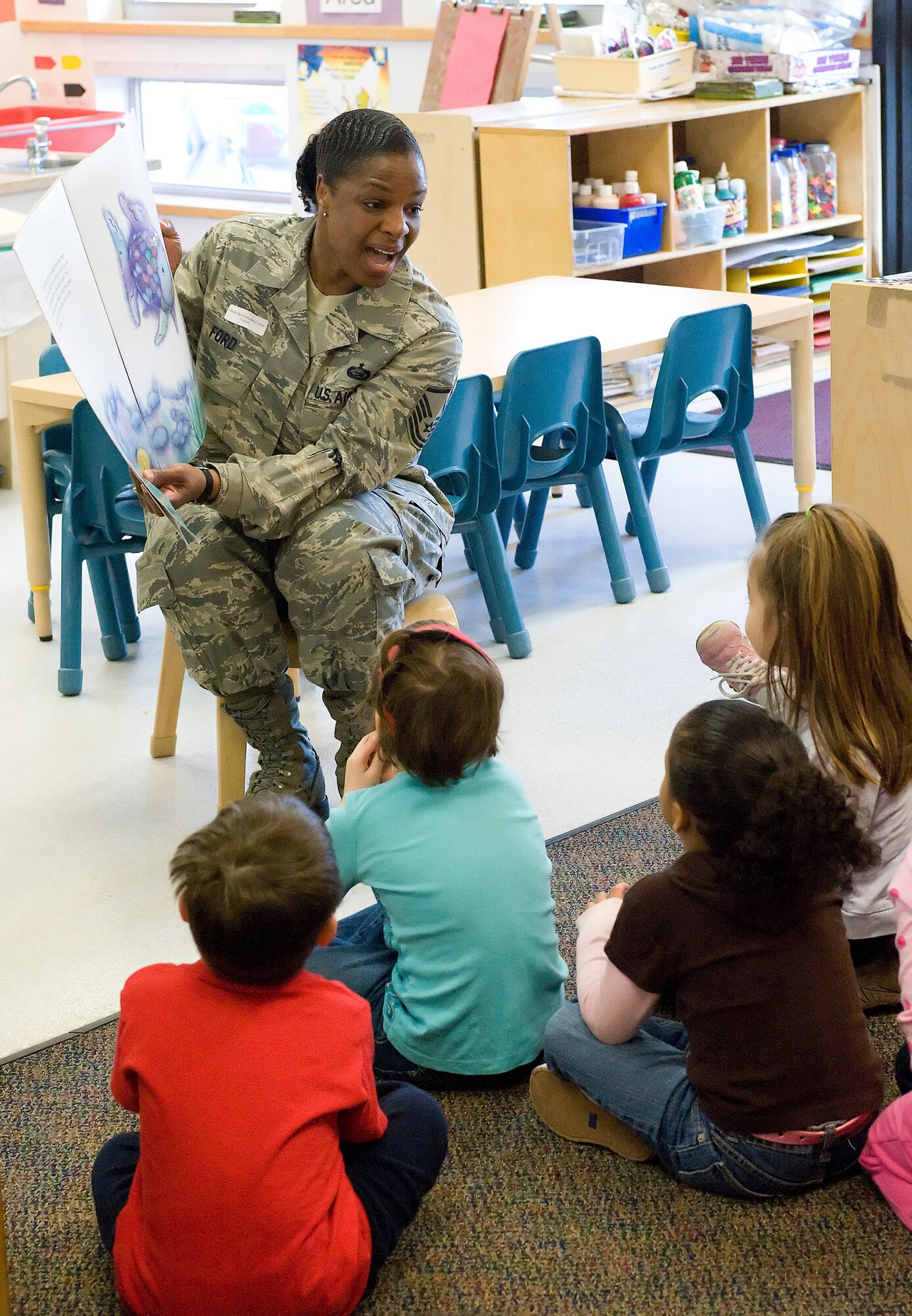 Master Sgt. Verna Ford, 436th Force Support Squadron NCO in-charge of the Airman and Family Readiness Center, reads ?The Rainbow Fish,? by Marcus Pfister, at the Child Development Center March 25. The Women?s History Month Committee read books to children at the CDC. (U.S. Air Force photo/Jason Minto)