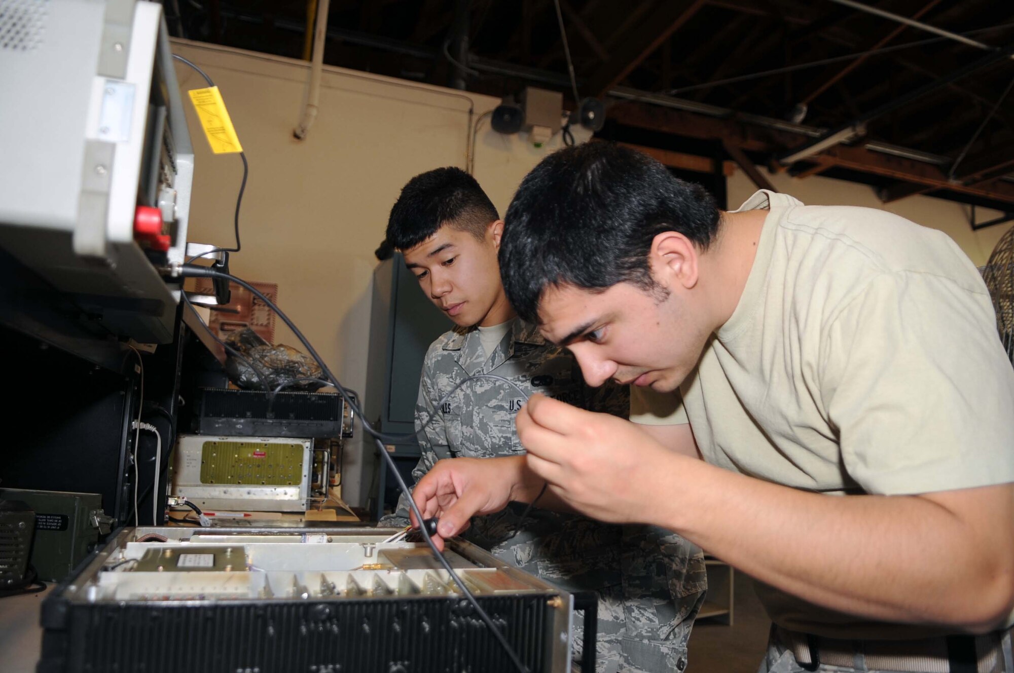 BARKSDALE AIR FORCE BASE, La. -- Staff Sgt. Charles Rodriguez (right), 2d Communications Squadron airfield systems maintenance technician, shows Airman 1st Class Jeffrey Sales, 2nd CS airfield systems maintenance technician, how to tune a radio transmitter March 23.  (U.S. Air Force photo by Staff Sgt. John Gordinier)