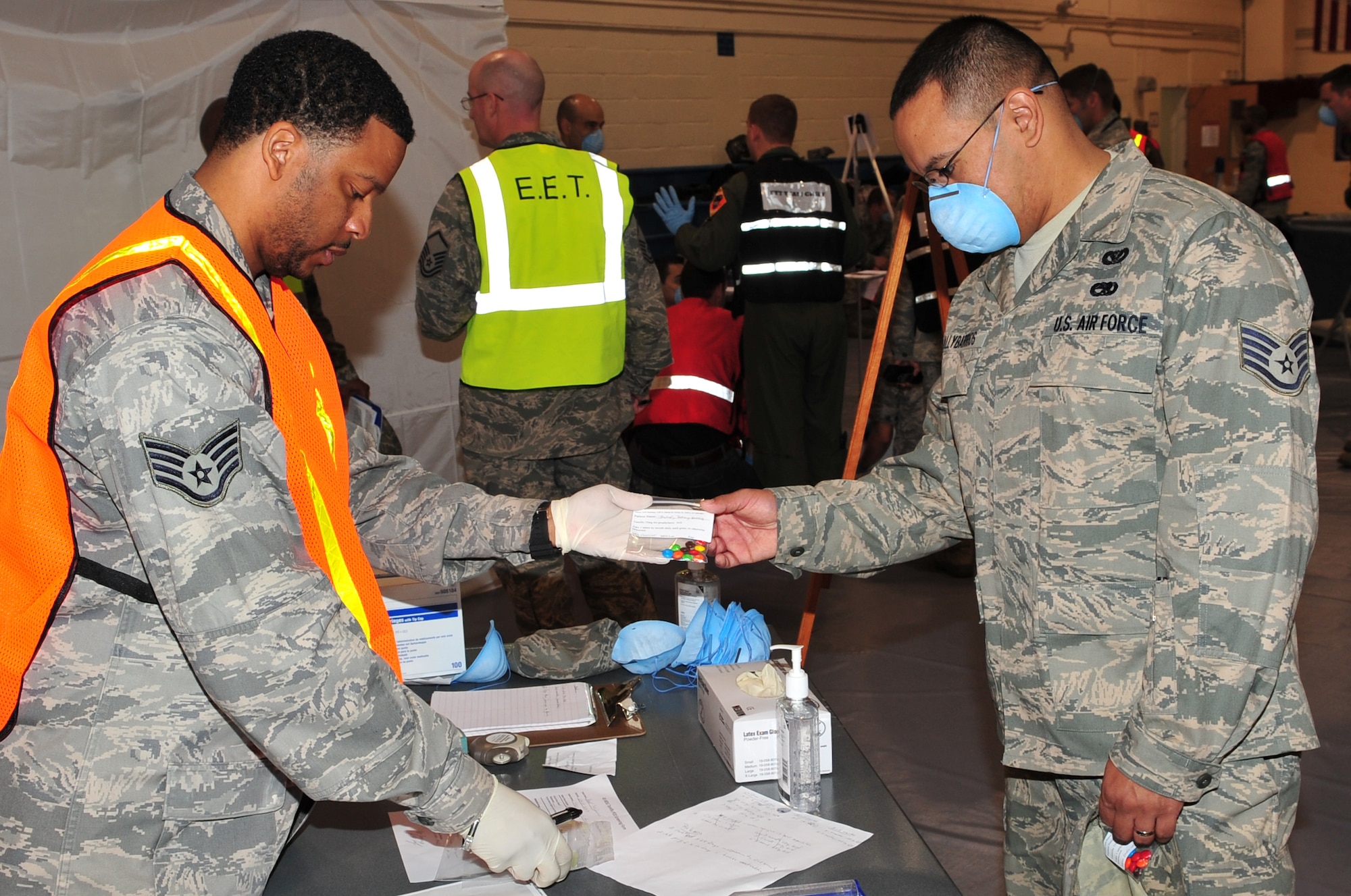 Staff Sgt. Odell Jones of the 45th Medical Support Squadron (left) passes out medication to a simulated patient during a 45th Medical Group exercise March 19 at the Patrick Fitness Center. The gymnasium became a point of dispensing, where the 45th MDG tested their ability to quickly treat a large number of people. (U.S. Air Force photo/Jennifer Macklin)