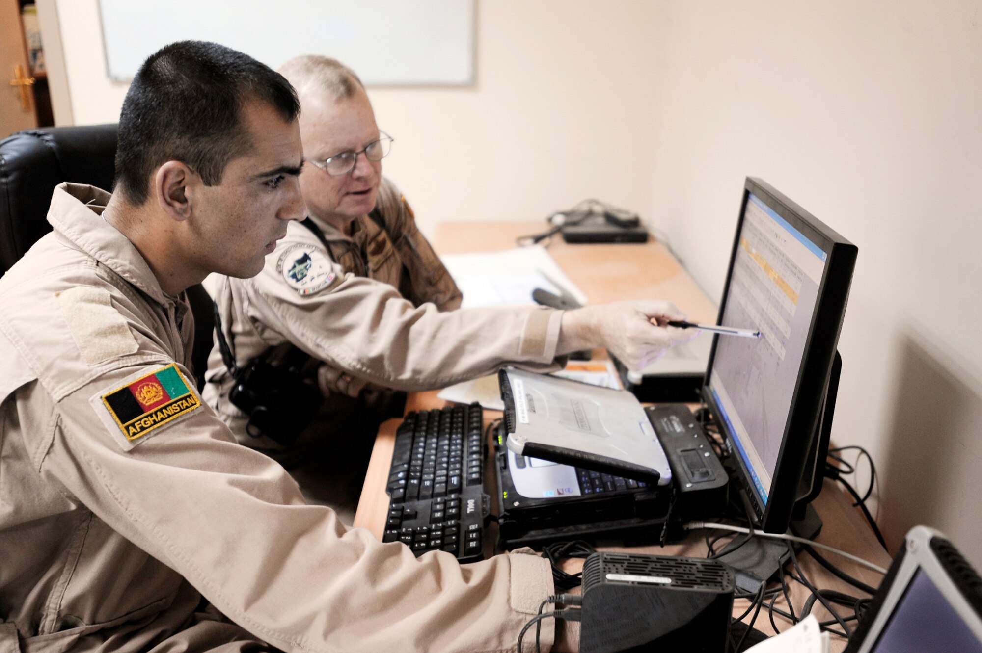 Afghanistan National Army Air Corps 1st Lt. Faiz M. Ramaki (left) and Lt. Col. Chris Kampsen review the flight plan for an ANAAC C-27 Spartan mission March 24, 2010, at Kabul International Airport, Afghanistan. Colonel Kampsen is the the director of operations for the 538th Air Expeditionary Advisory Squadron and a C-27 instructor pilot. Lieutenant Ramaki is an ANAAC C-27 pilot. (U.S. Air Force photo/Staff Sgt. Manuel J. Martinez)