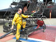 Col. Jeffrey Mineo, 940th Wing Commander, pops the cork on a bottle of champagne in a traditional celebration of his safe return from the edge of the earth's atmosphere.  The colonel flew in a U-2 Dragonlady piloted by Capt. Josh Tull, 1st Reconnaissance Squadron, on March 24 from Beale Air Force Base, Calif.  (U.S. Air Force Photo/Dana LIneback)