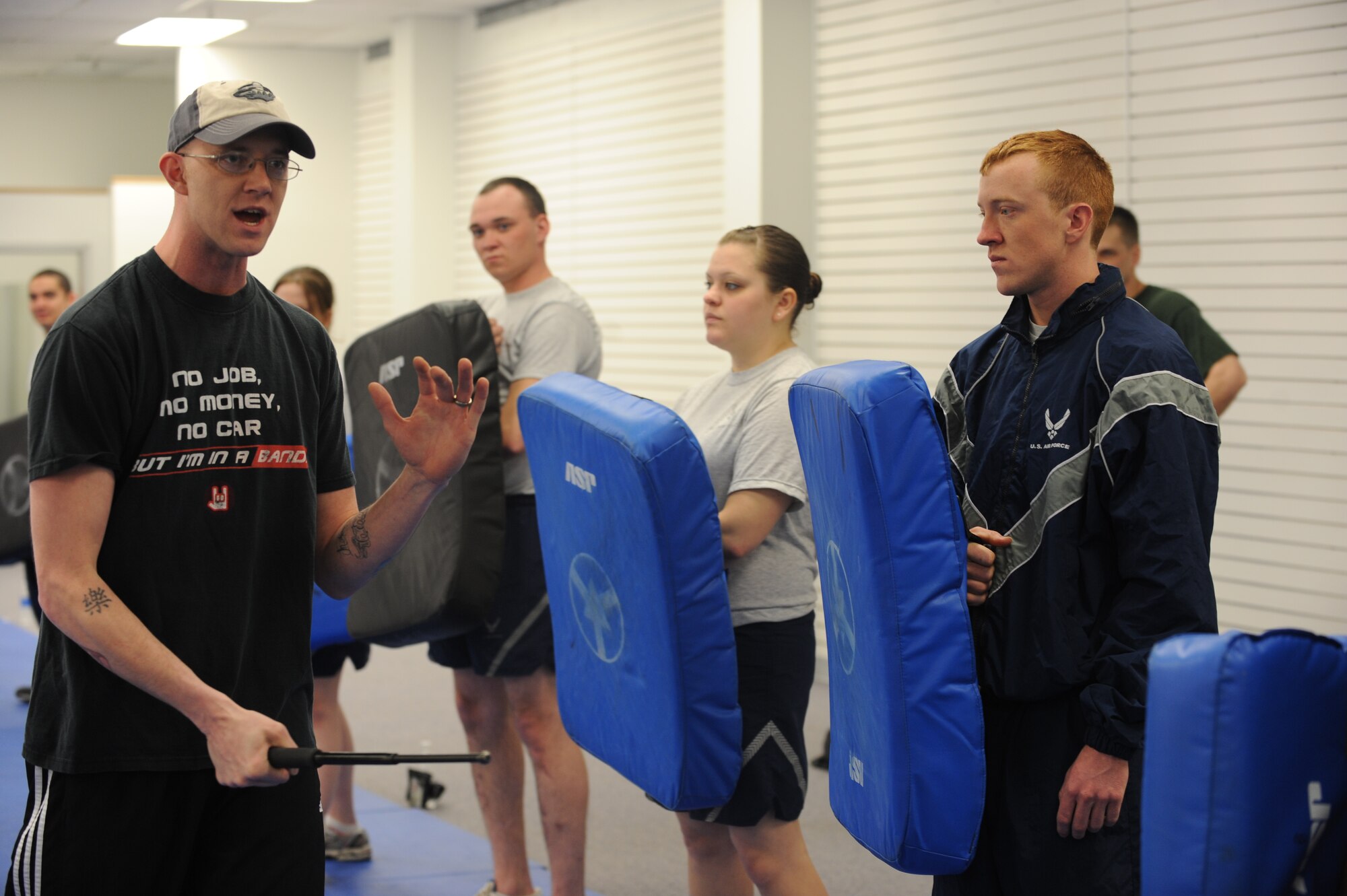 MINOT AIR FORCE BASE, N.D. -- Tech. Sgt. Bradley Tarbox, an instructor from the 5th Security Forces Squadron, leads a group of Airmen in a baton training class at Minot Air Force Base March 17. The 5th SFS Airmen attend this weekly training to learn how to defend themselves against an attacker. The instructors wear protective padding while the students put the skills they have learned to the test. (U.S Air Force photo by Staff Sgt. Stacy Moless)