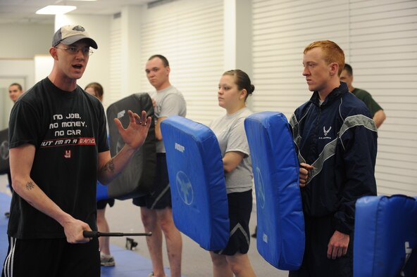MINOT AIR FORCE BASE, N.D. -- Tech. Sgt. Bradley Tarbox, an instructor from the 5th Security Forces Squadron, leads a group of Airmen in a baton training class at Minot Air Force Base March 17. The 5th SFS Airmen attend this weekly training to learn how to defend themselves against an attacker. The instructors wear protective padding while the students put the skills they have learned to the test. (U.S Air Force photo by Staff Sgt. Stacy Moless)