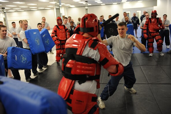 MINOT AIR FORCE BASE, N.D. -- Airman 1st Class Dalton Wood, a 5th Security Forces Squadron member, uses the techniques he just learned in the baton training class to take down his “attacker” at Minot Air Force Base March 17. The 5th SFS Airmen attend this weekly training to learn how to defend themselves against an attacker. The instructors wear protective padding while the students put the skills they have learned to the test. (U.S Air Force photo by Staff Sgt. Stacy Moless)