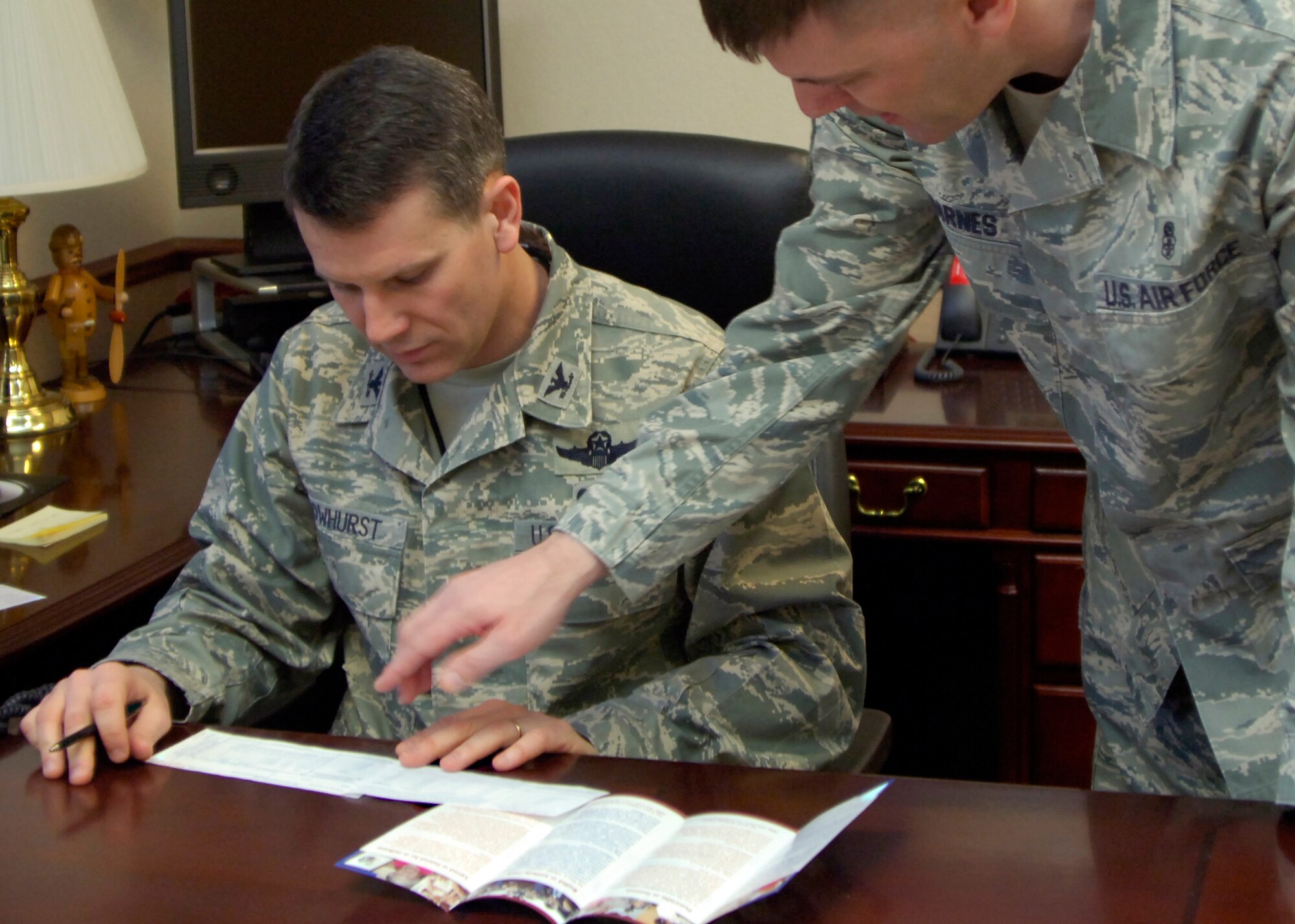 Col. James Crowhurst, 22nd Air Refueling Wing commander, reviews an Air Force Assistance Fund donation form with the help of Master Sgt. Wilmer Barnes, 22nd Aerospace Medicine Squadron, installation project officer for the AFAF, March 23, 2010, at McConnell Air Force Base, Kan. Unit AFAF representatives have helped the base reach a quarter of its $49,620 goal in the first week of the campaign which ends April 25. (U.S. Air Force Photo/Senior Airman Maria Ruiz)