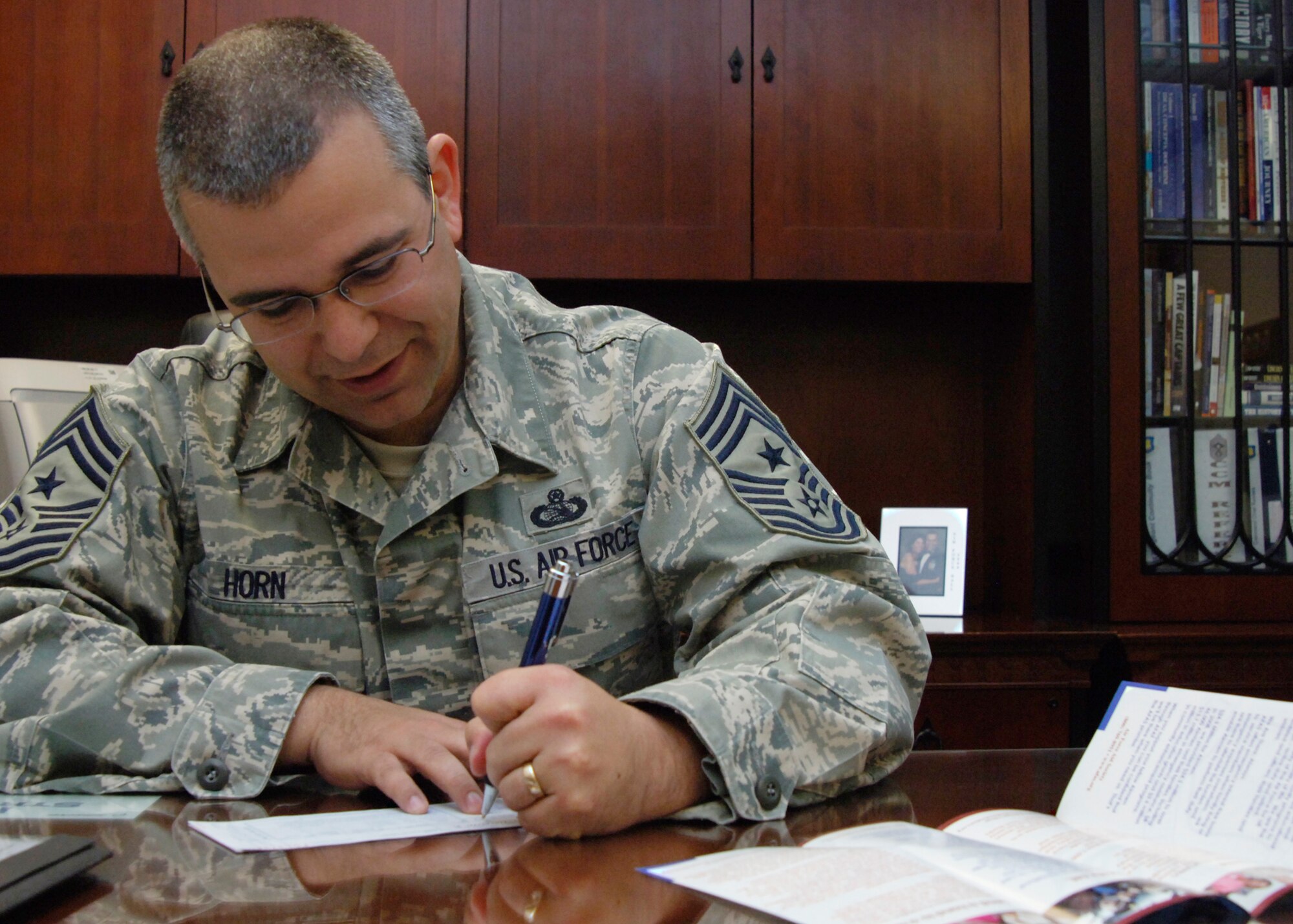 Chief Master Sgt. Timothy Horn, 22nd Air Refueling Wing command chief, signs an Air Force Assistance Fund donation form, March 23, 2010, McConnell Air Force Base, Kan. The AFAF assists Airmen from around the world by donating to the following organizations: Air Force Aid Society, Air Force Enlisted Village, Air Force Village and LeMay Foundation. Each organization helps a specific cause by providing emergency assistance to Airmen and their families, temporary housing for surviving spouses of fallen enlisted members or assistance for Air Force widows. (U.S. Air Force photo/Senior Airman Maria Ruiz)