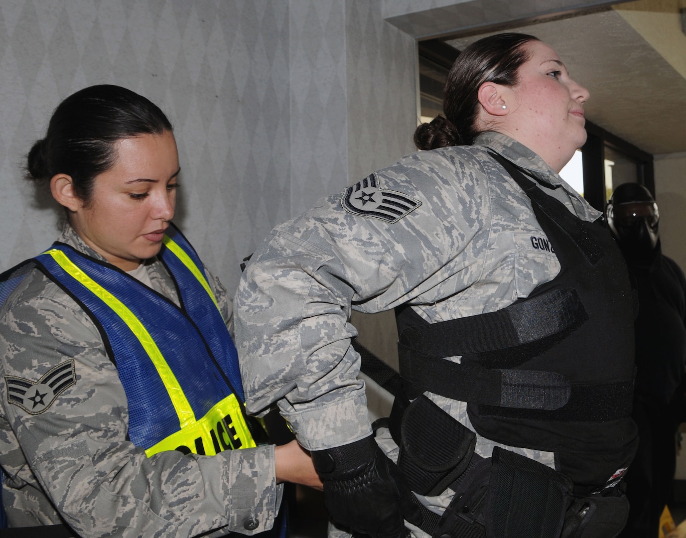 Staff Sgt. Marisela Gonzales, right, of the 902nd Security Forces Squadron at Randolph Air Force Base gets assistance from Senior Airman Mida Dekzeypros to adjust her vest and safety gear before entering the old Randolph BX facility during Active Shooter Training March 24, 2010.  (U.S. Air Force photo by Don Lindsey)