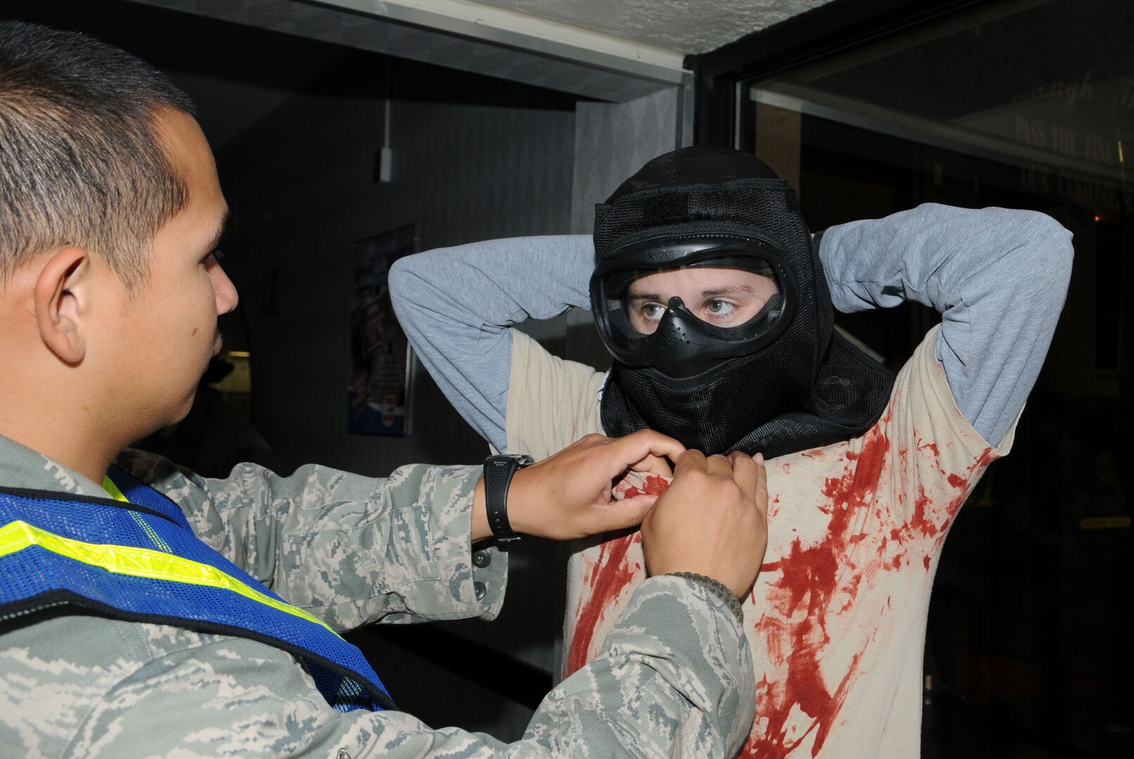 Staff Sgt. Jeff Reyes, left, helps Staff Sgt. Krystal Kanaday secure her mask prior to active shooter training at the Randolph Air Force Base old Base Exchange complex.  Randolph Security Forces conduct training in the old Randolph BX facility on how to secure a facility after a shooter has taken control of the building. (U.S. Air Force photo by Don Lindsey)