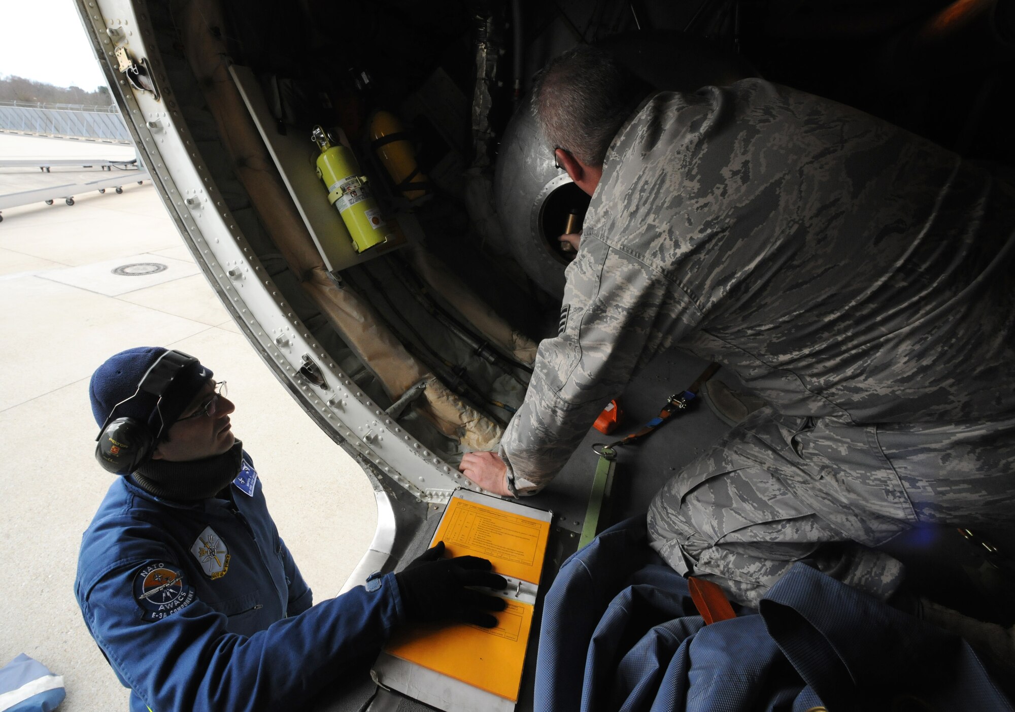 NATO AIR BASE GEILENKIRCHEN, Germany – Tech. Sgt. Richey Leamer, right, NATO E-3A Airborne Early Warning and Control force component E-3A Sentry crew chief, and Greek air force Master Sgt. Ilias Raptis, NATO E-3A AWACS component E-3A training crew chief, inspect a processing unit inside an E-3A March 19. The E-3A component is made of 15 nations and is NATO’s only multinational operational flying unit. (U.S. Air Force photo/Senior Airman Nathanael Callon)