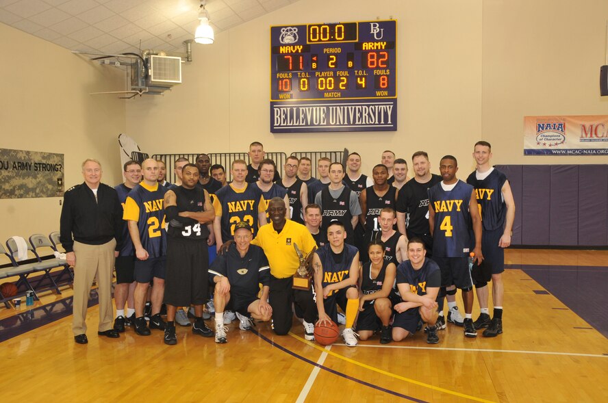 BELLEVUE, Neb. - Vice Adm. Carl V. Mauney, deputy commander, U.S. Strategic Command, and Maj. Gen. Abraham J. Turner, chief of staff, USSTRATCOM pose with both teams following the USSTRATCOM Army Navy basketball game March 19 at Bellevue University's Gordon Lozier Athletic Center. Army beat Navy with a final score of 82 - 71. U.S. Air Force photo by Steve Cunningham
