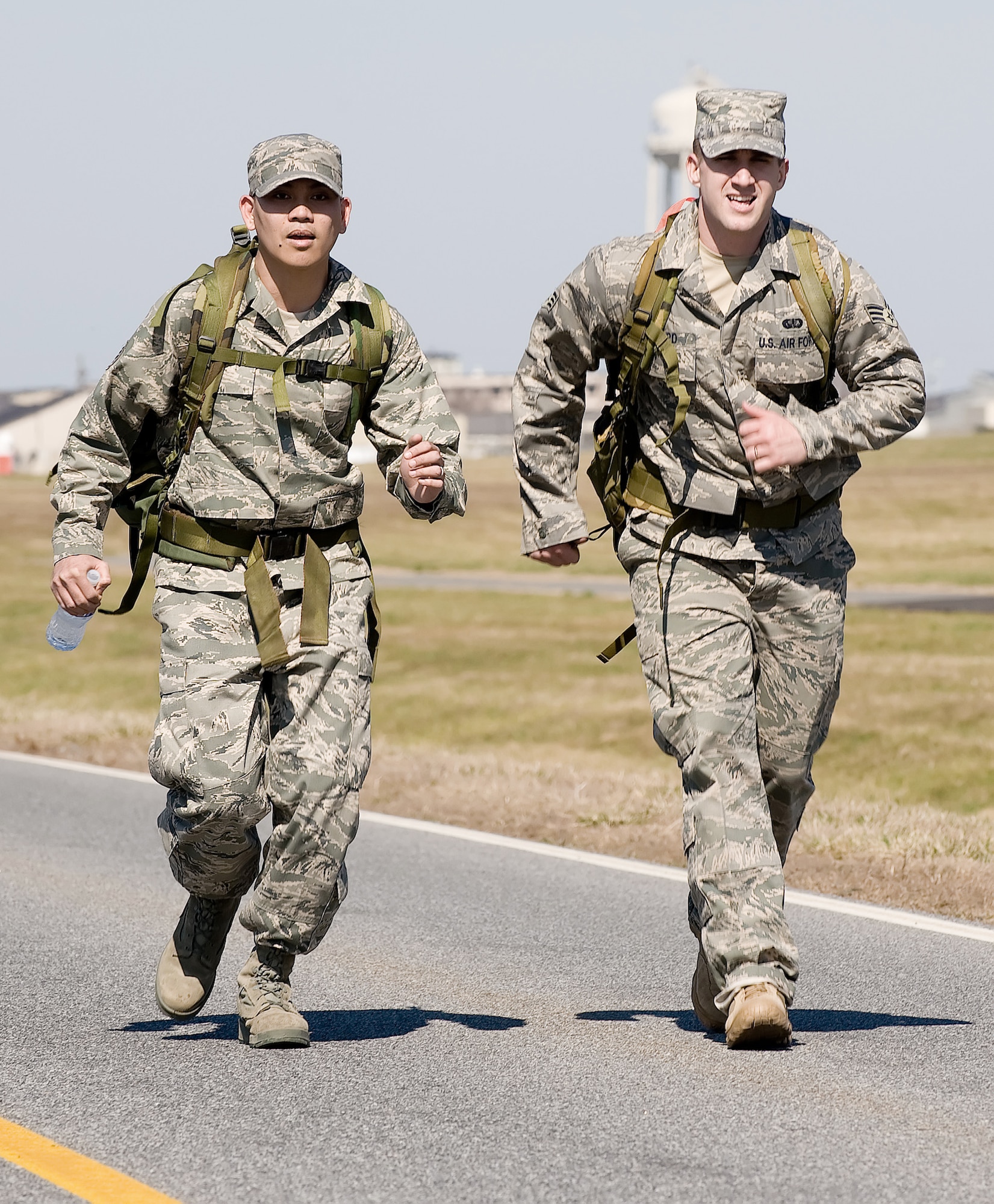 Staff Sgt. Herbert Dungca (left) and Senior Airman Jonathan Howard pick up the pace during the 436th Security Forces Squadron's 11th Annual Ruck March held March 20, 2010, at Dover Air Force Base, Del. The annual 6.2-mile march is a fundraiser to honor the veterans of the Korean War who fought in the Battle of the Chosin Reservoir. Sergeant Dungca and Airman Howard are Air Force Mortuary Affairs Operations Center dignified transfer team members. (U.S. Air Force photo/Jason Minto)