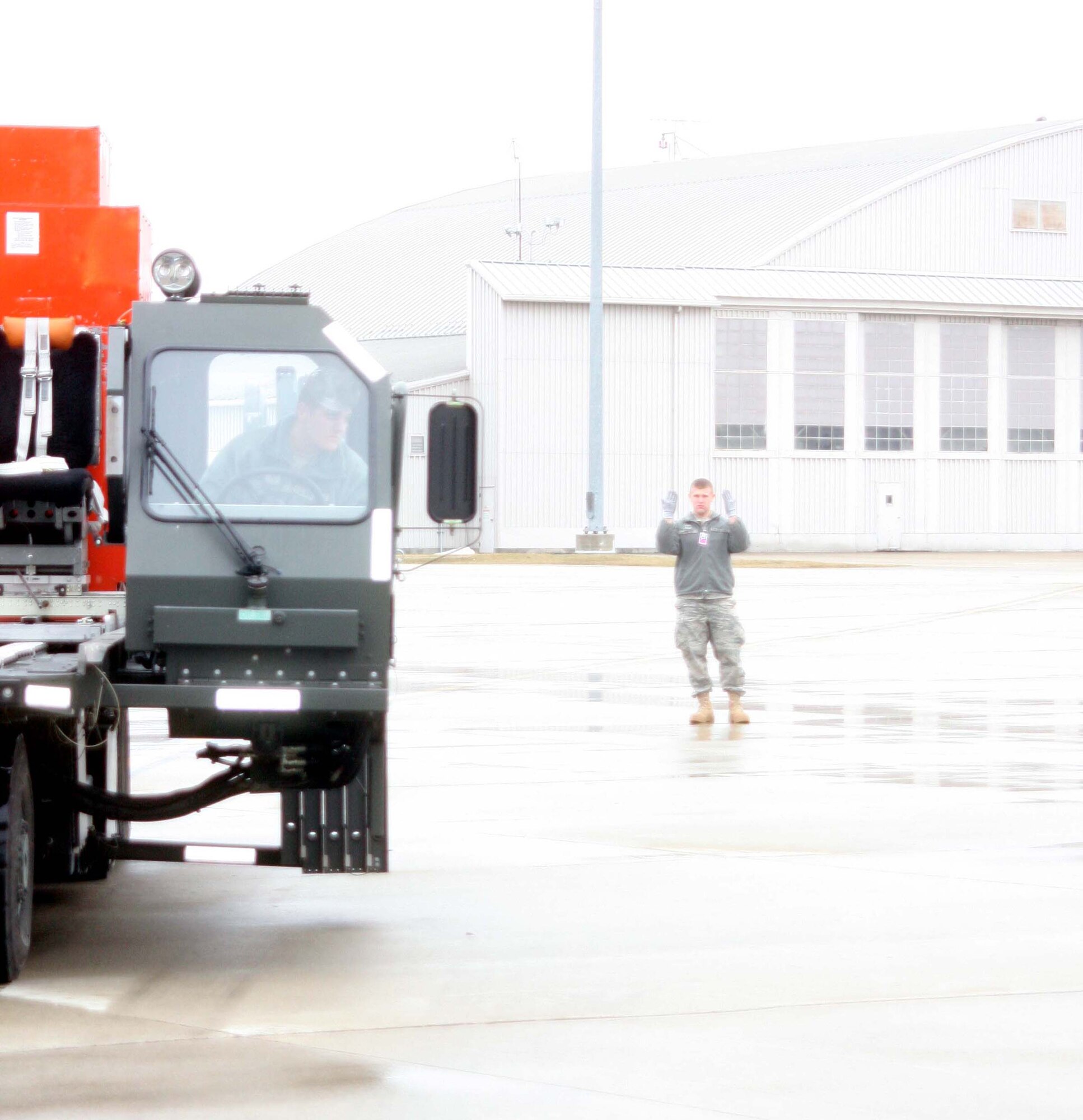 WRIGHT-PATTERSON AIR FORCE BASE, Ohio – Senior Airman Chris Spencer, watches his guide, Staff Sgt. Alex Peiffer, both from the 87th Aerial Port Squadron, closely while driving next to a C-130 Hercules that his unit will be loading cargo onto during the March 14 unit training assembly.  (U.S. Air Force photo/Staff Sgt. Amanda Duncan)